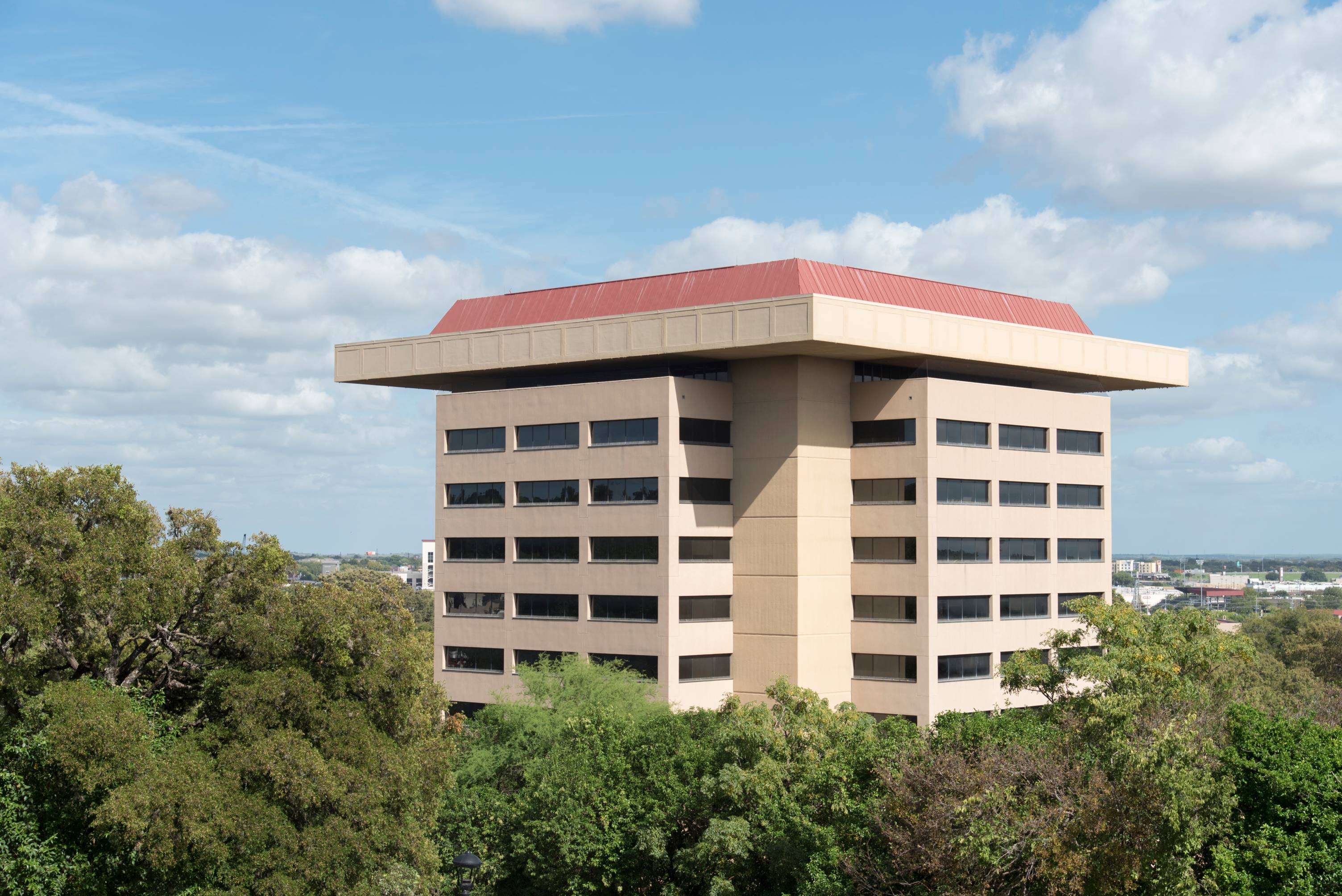 Aerial view of J. C. Kellam Administrative Building and surrounding trees in front of a bright blue sky