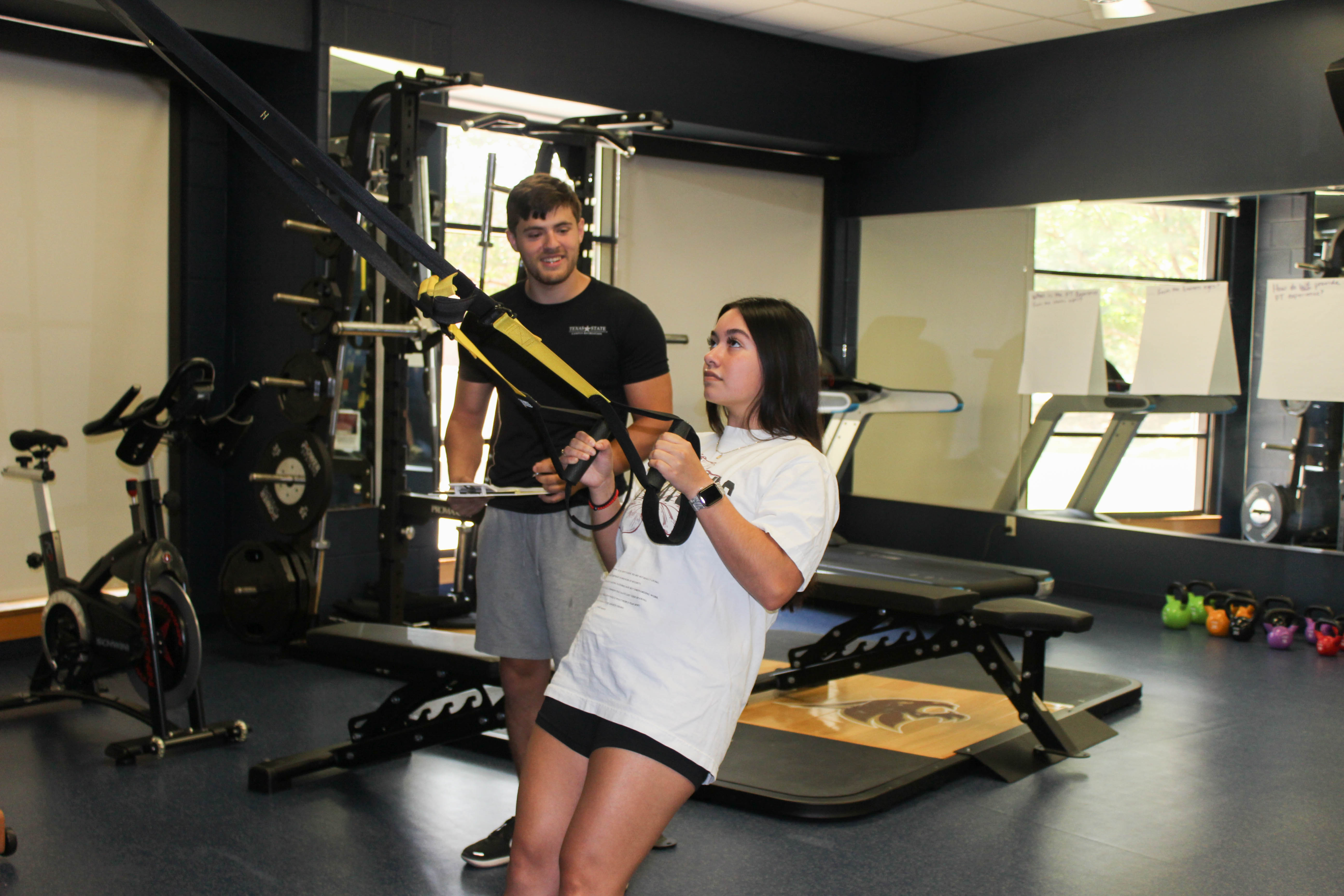 A trainer helping a student workout