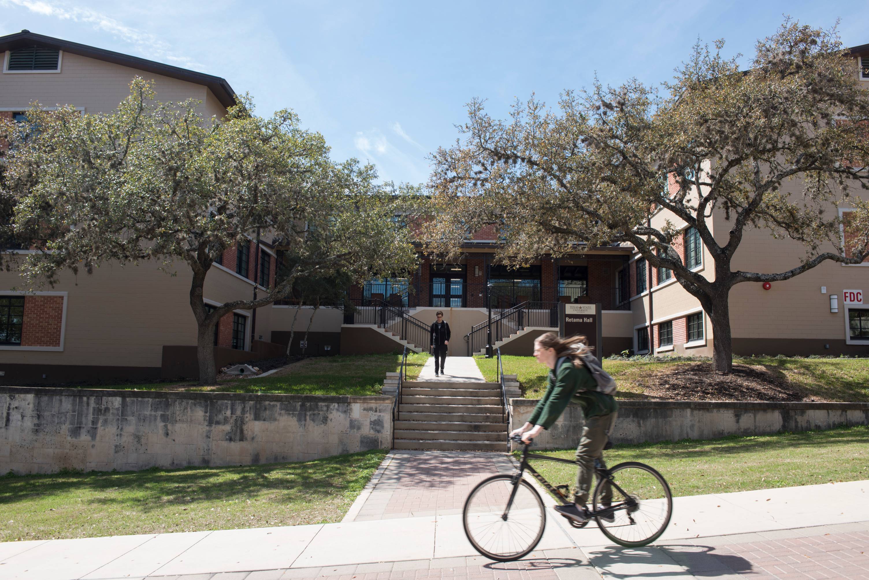 student riding their bike on campus 