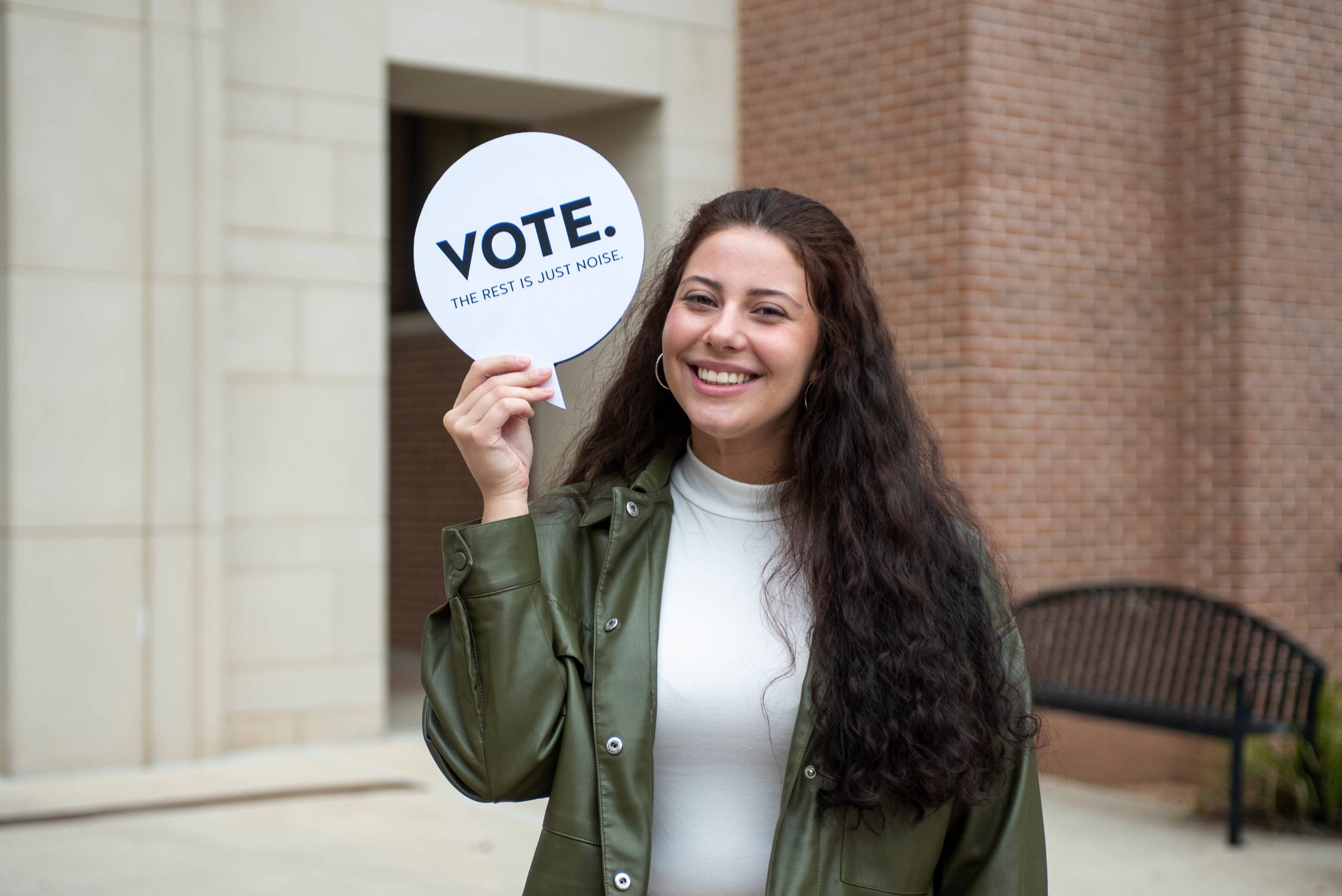 student holding a vote sign