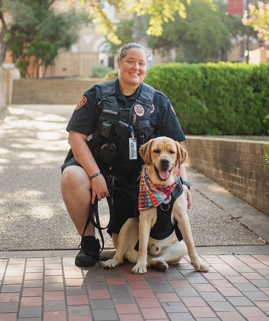 police officer kneeling next to yellow lab