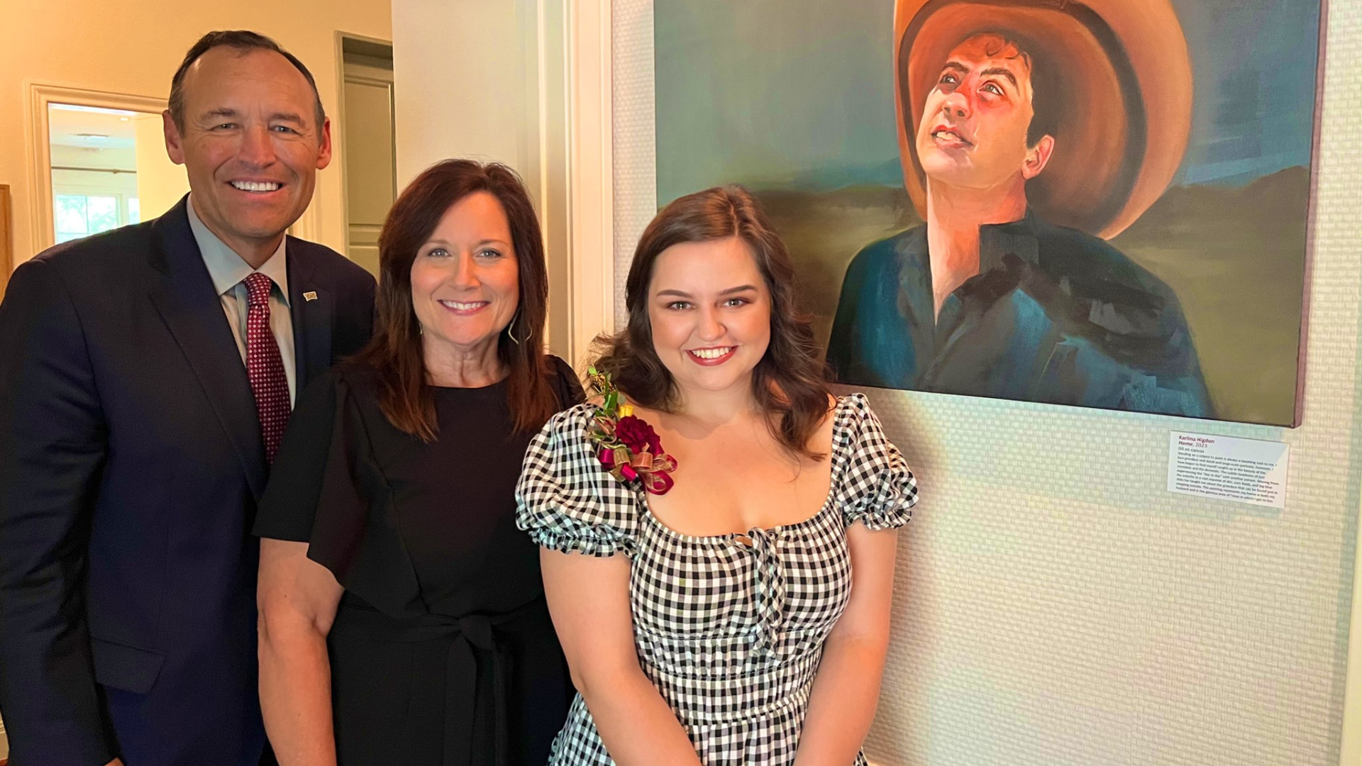 President Damphousse & Beth Damphousse pose with student Karlina Higdon whose artwork was exhibited in the Damphousse's home.  