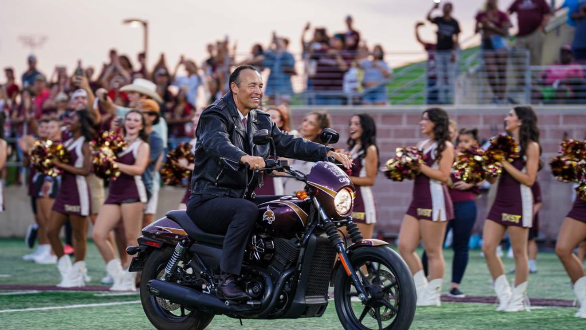 President Damphousse rides a motorcycle into Bobcat Stadium during the opening home football game. 
