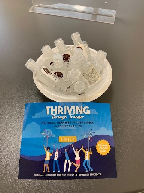 bowl of hand sanitizers and flier that says "Thriving through Transfer"