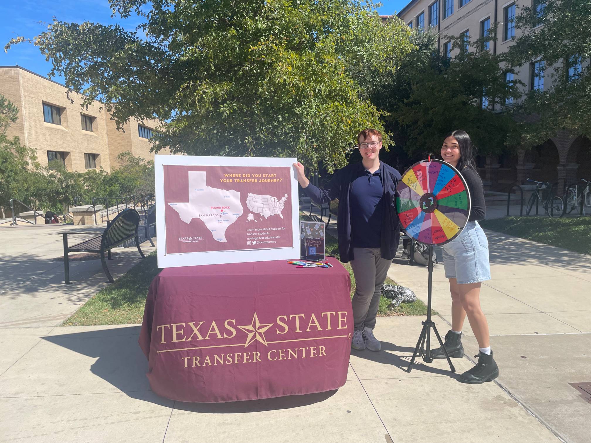 two students are by a prize wheel and map