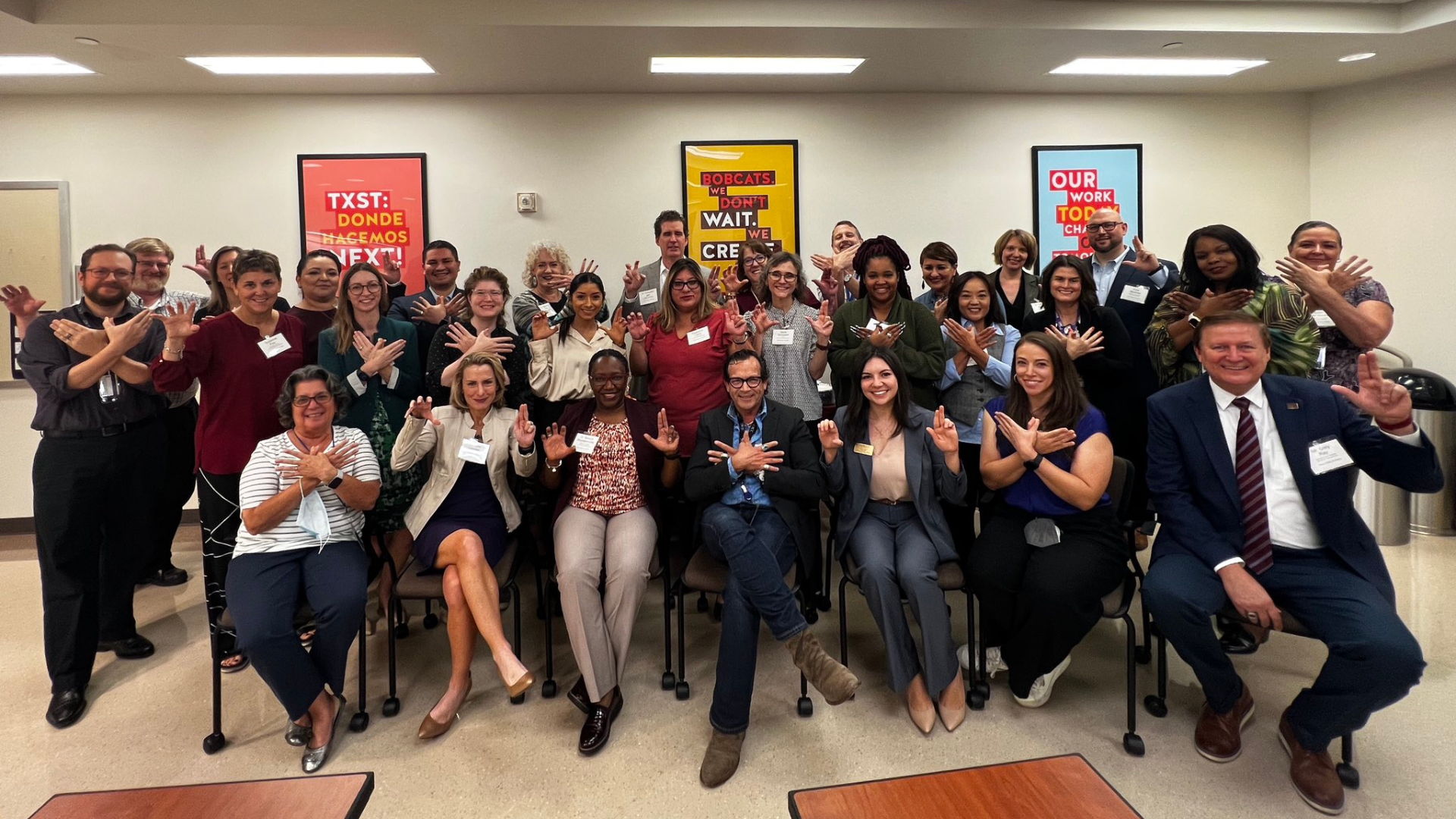 ACC and TXST professionals display their colleges' hand signs