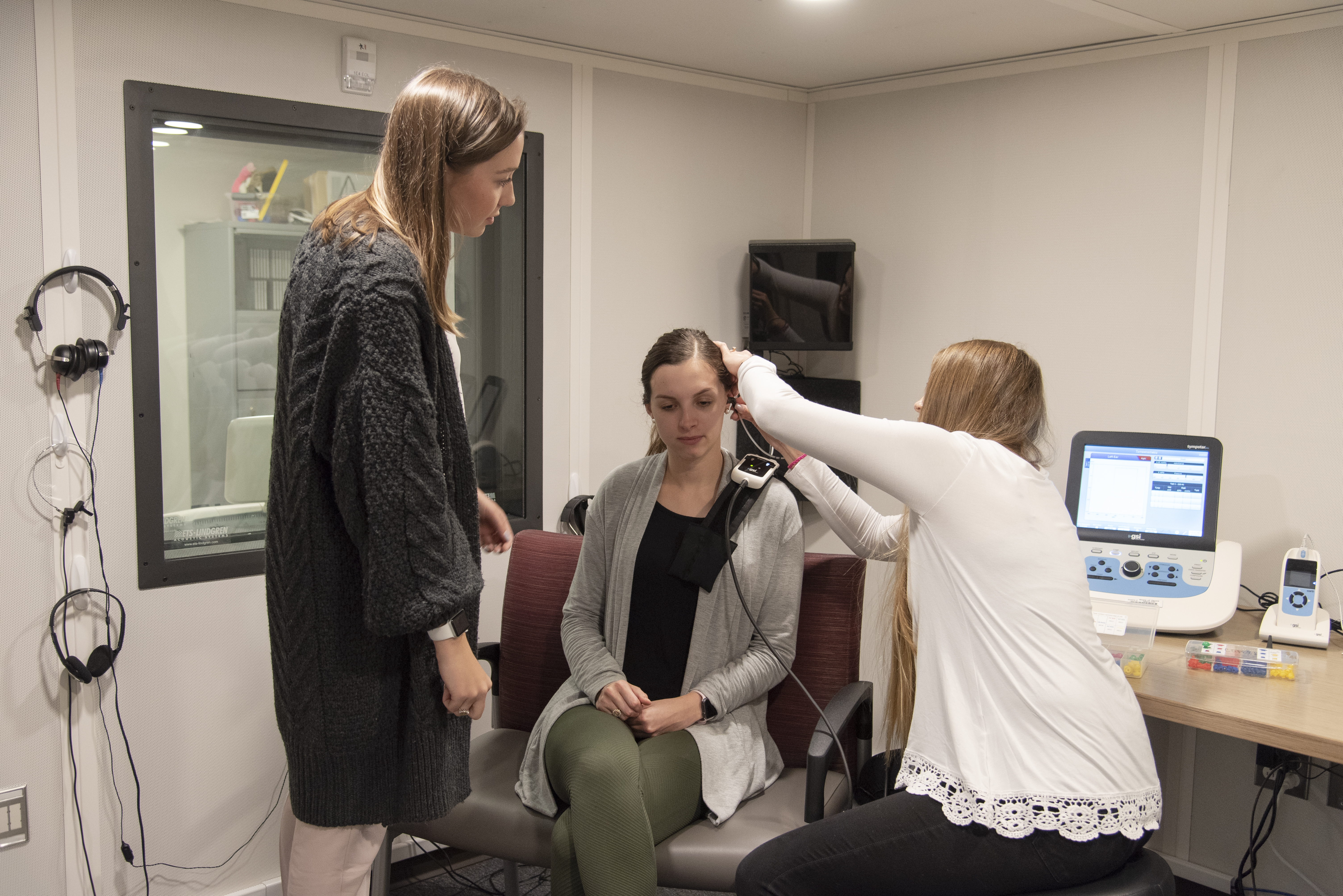 A group of students from TXST are testing the communication disorder equipment