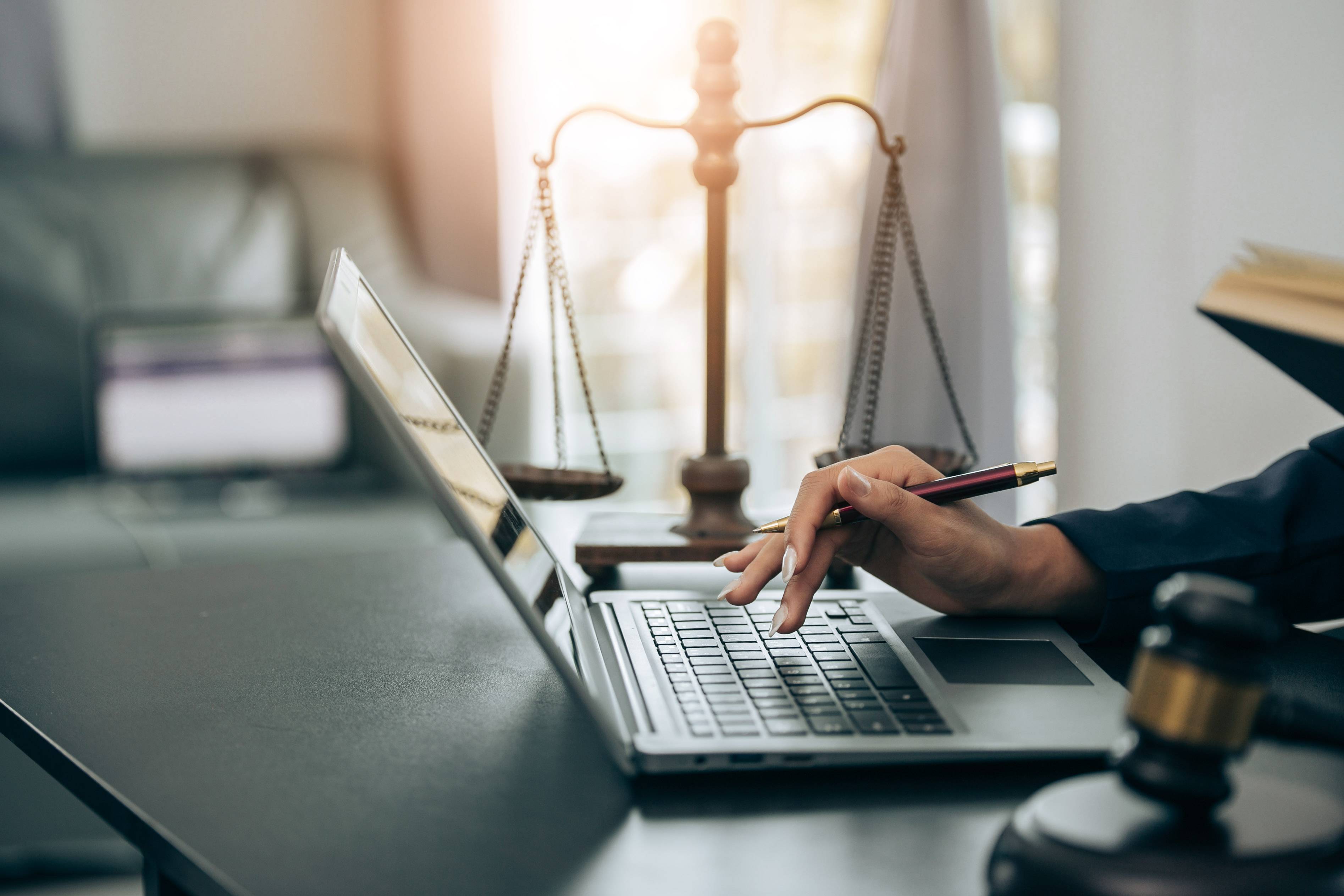 A stock image of someone working on a computer in a courtroom.