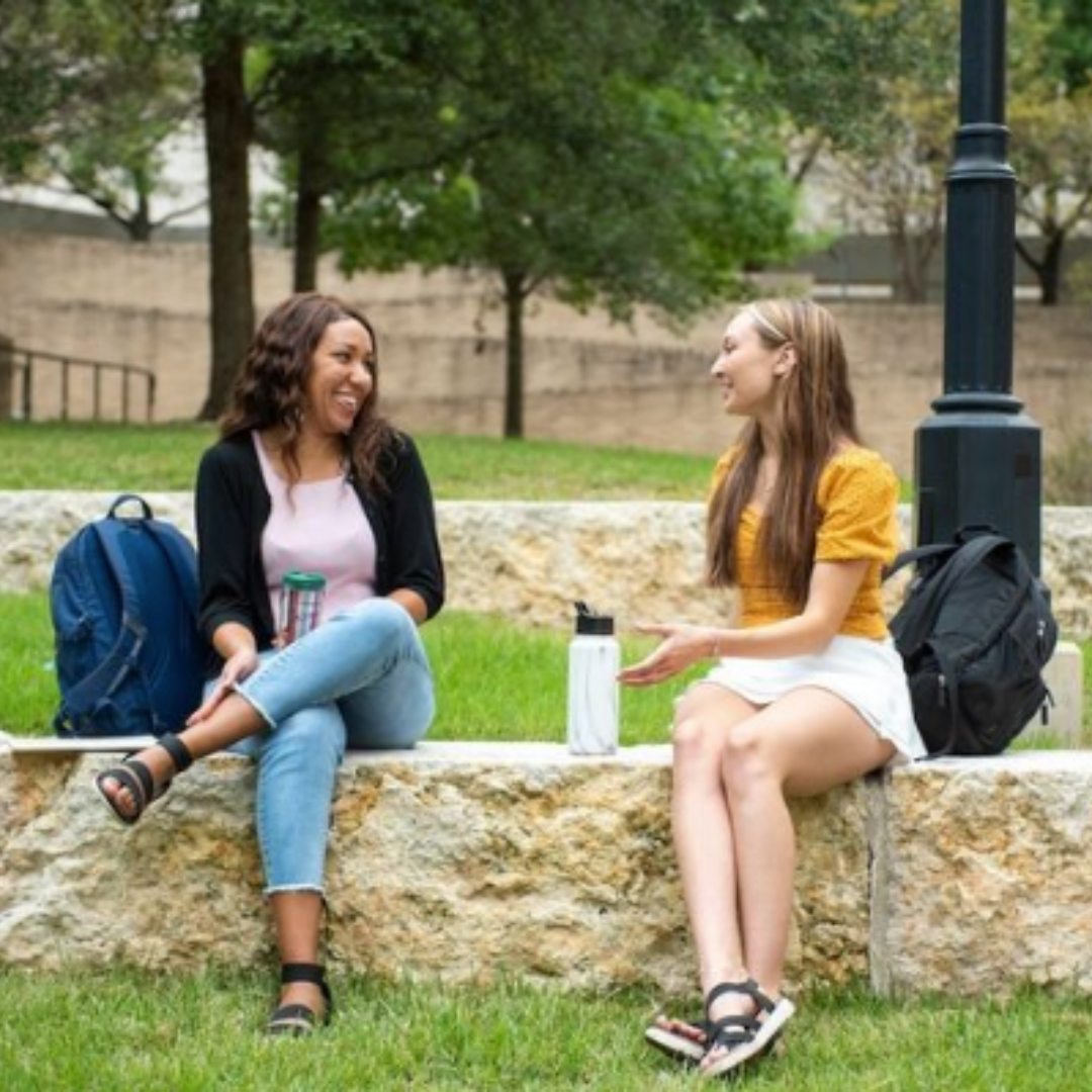 Two students chatting outside. Links to Financial Aid website