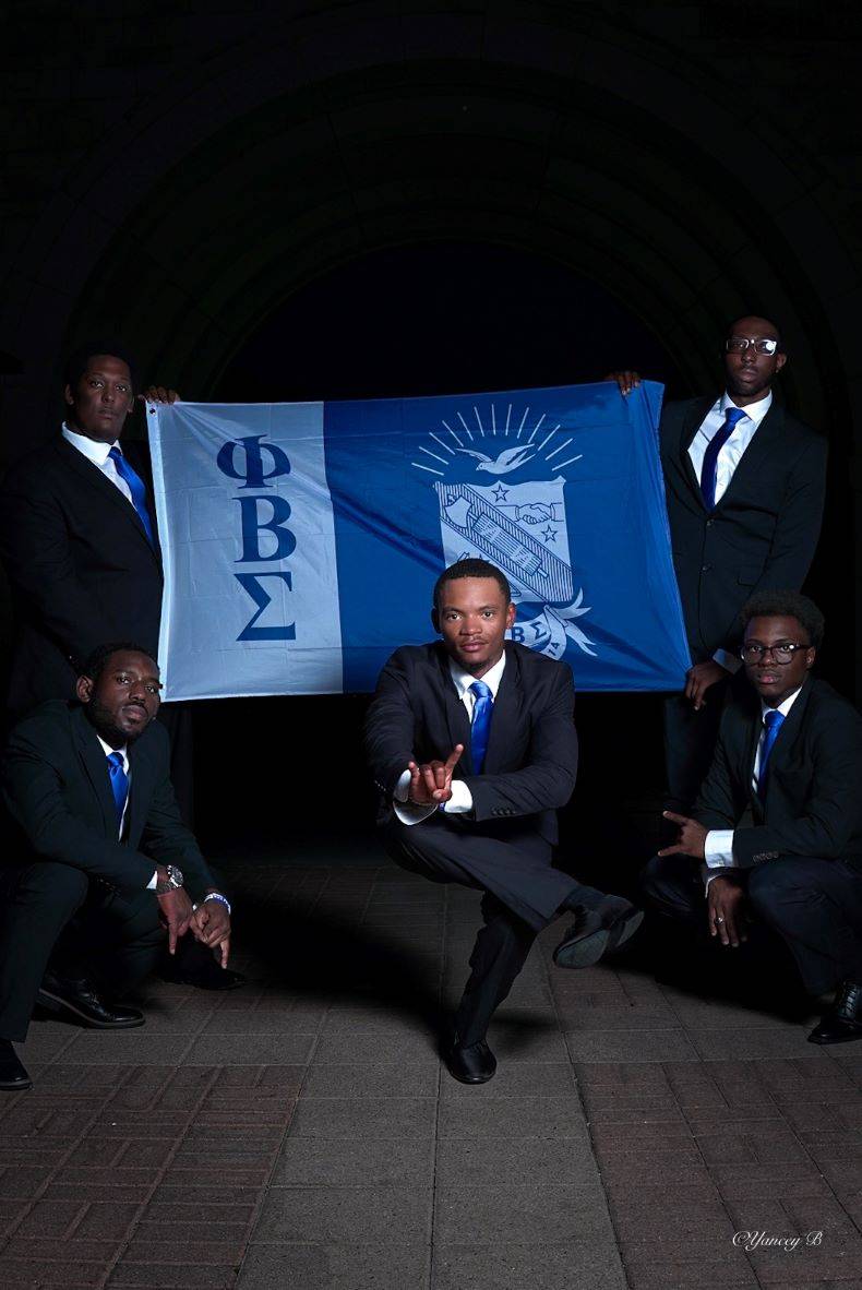 Phi Beta Sigma men posing with a chapter flag