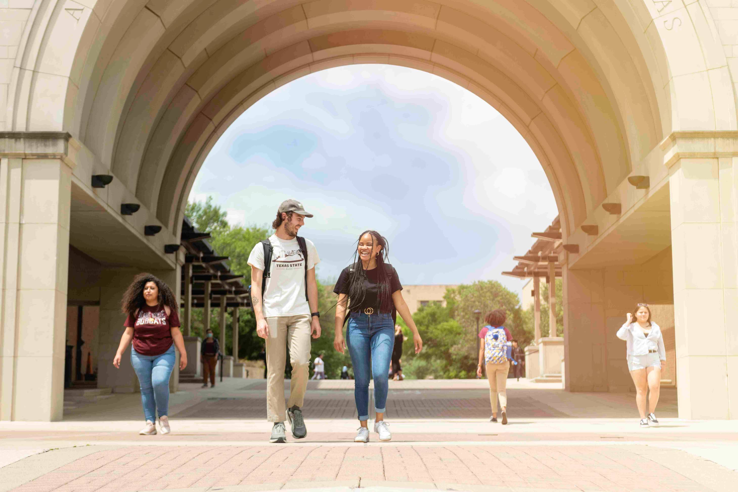 Students walking past campus arch
