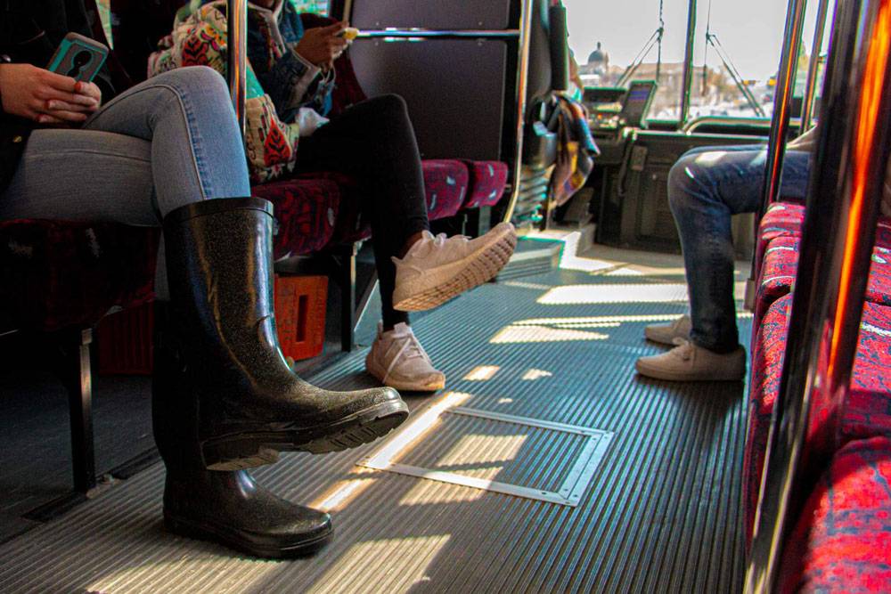 Three Bobcat Shuttle passengers, phones in hand, happy they're not hunting for a parking spot.