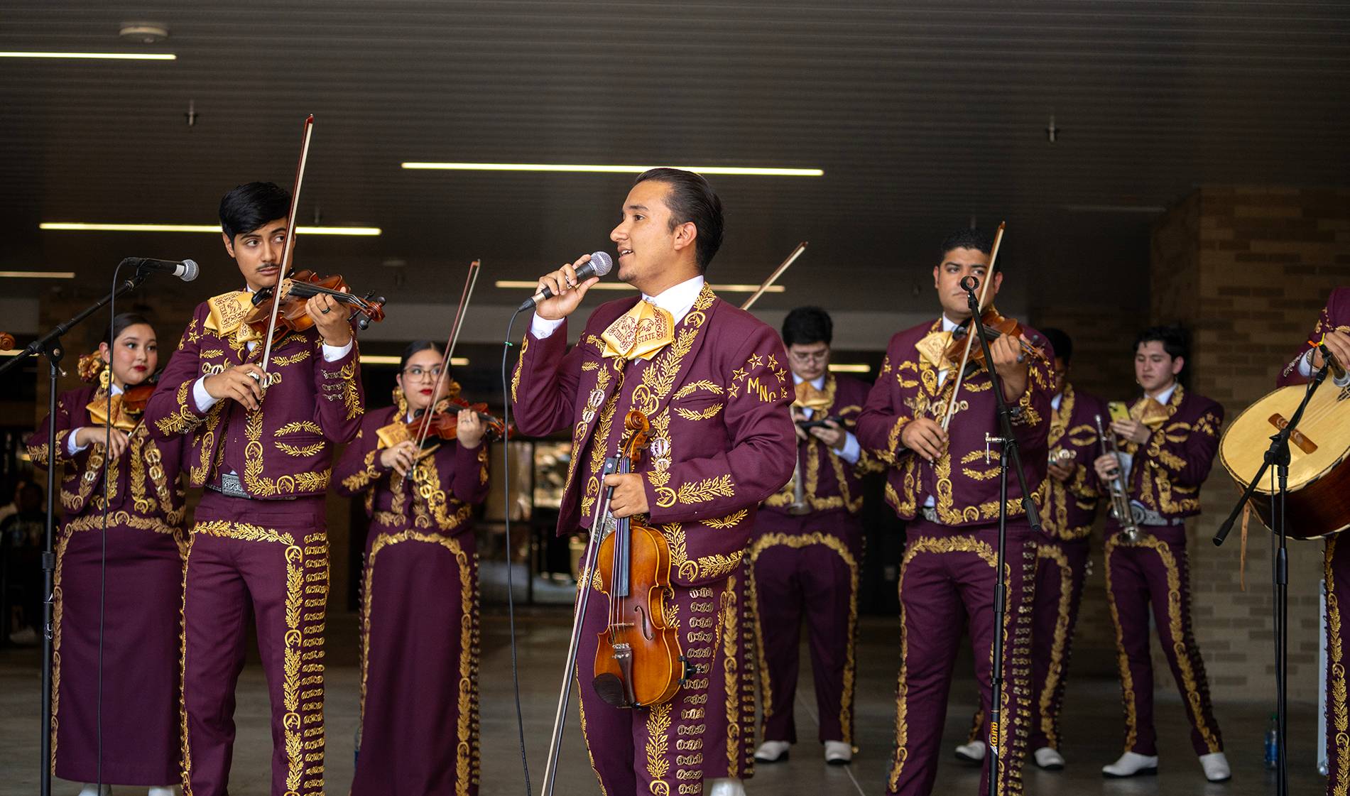 man in mariachi band singing into a microphone
