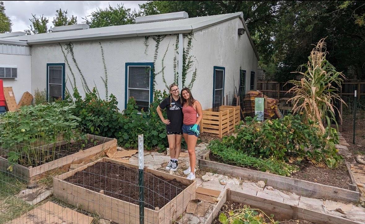 Liz Kryznefsk, left, senior programs director of youth and family at the YMCA, and Madelyn Parsons, junior criminal justice major and Stelos Scholar student, pose for a picture in the community garden.
