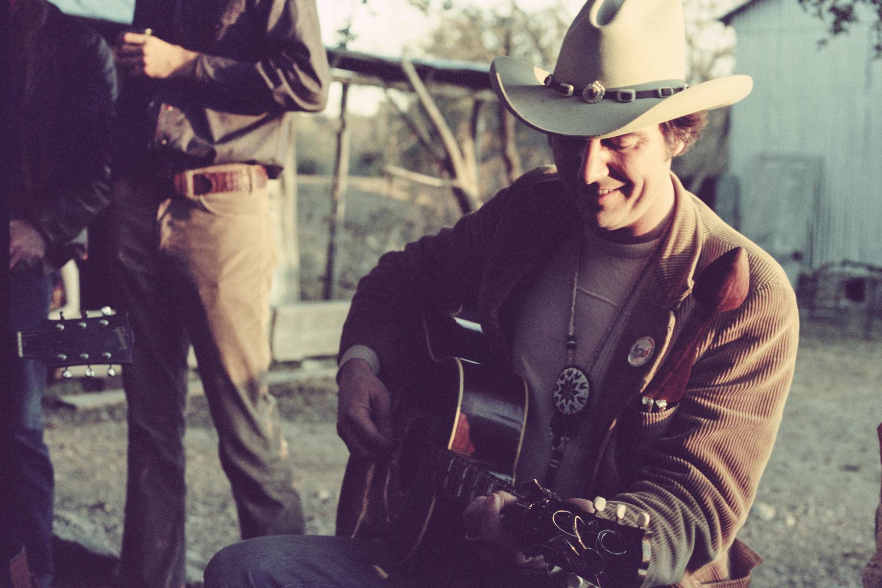 man in cowboy hat plays a guitar