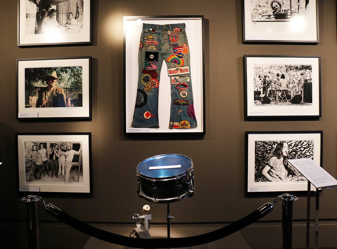 photographs and personal items hung on a wall during a gallery exhibit