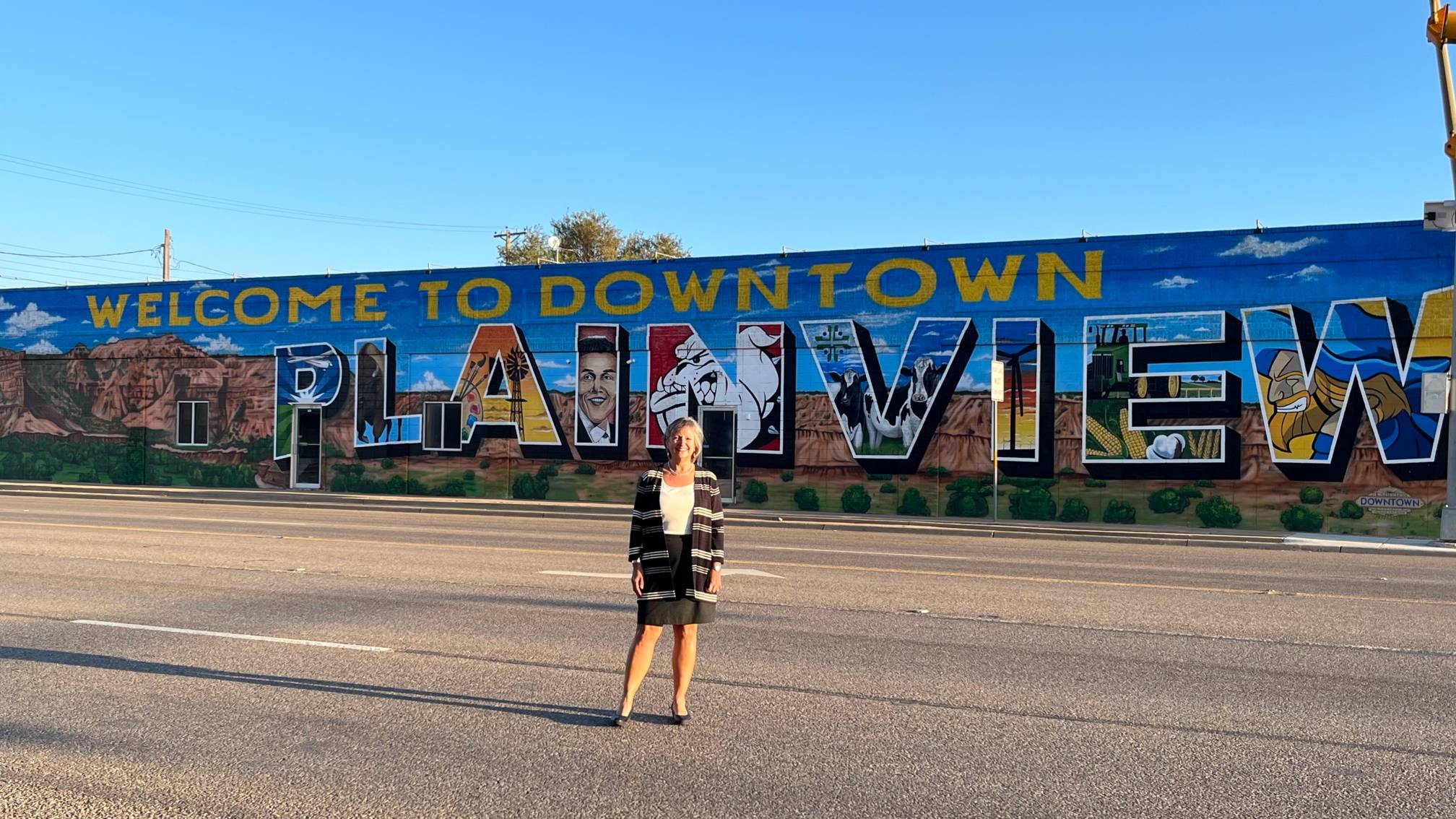 faculty member in front of Mural in plainview texas