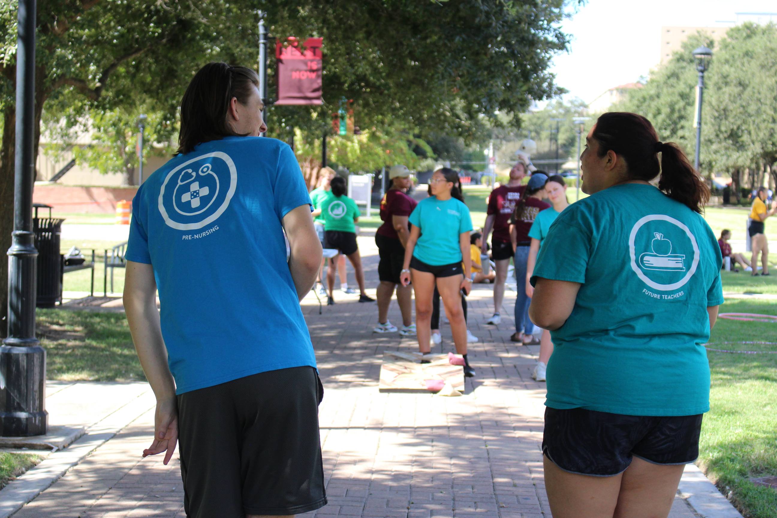 Two students in LLCs playing a game outside