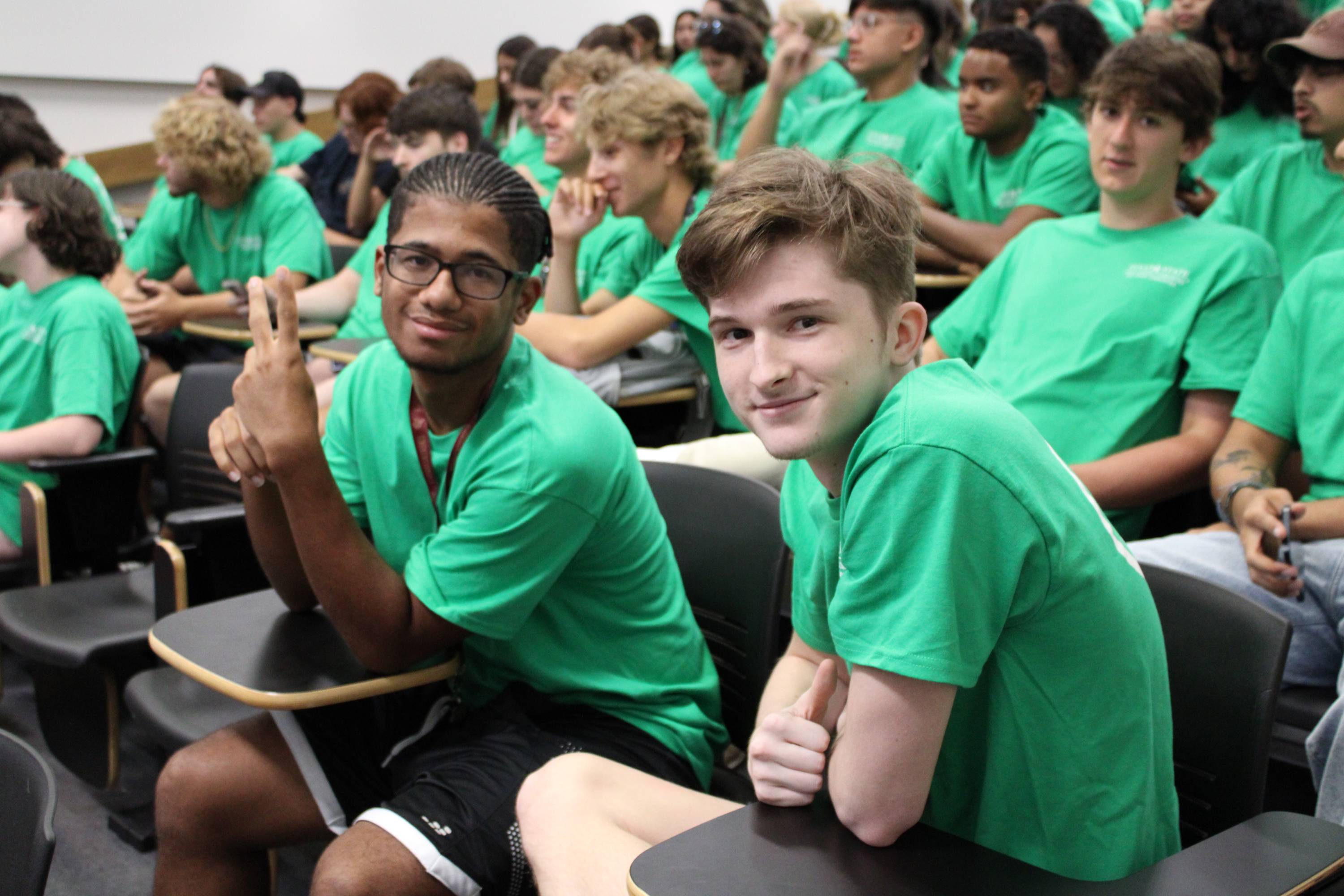 Two business LLC students in matching green shirts