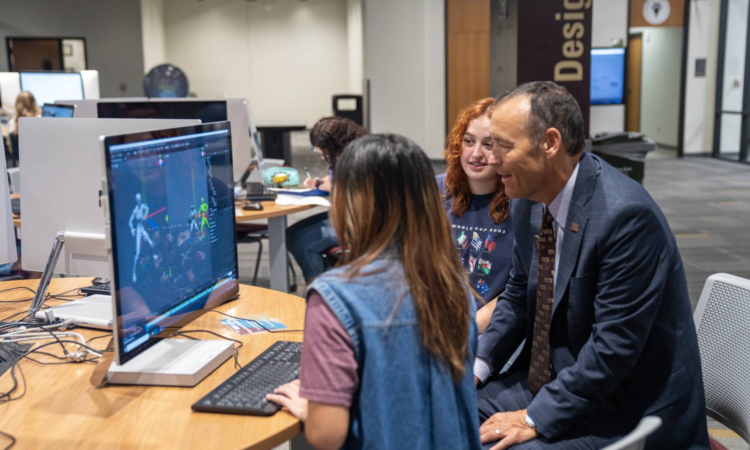 President Damphousse and students explore 3D imagery on specialized computers in Alkek One