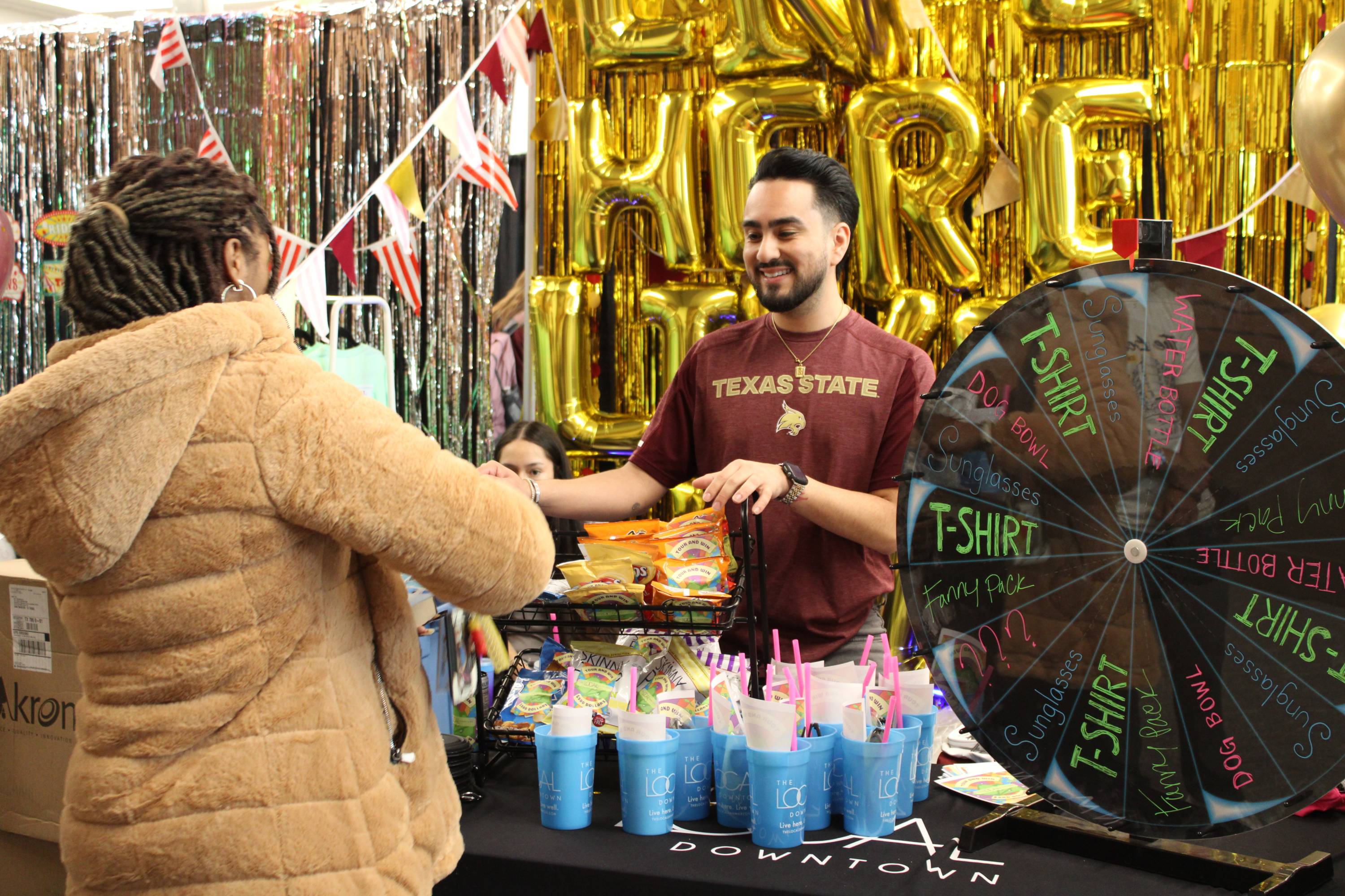 Male and Female smiling and talking at a tabling event