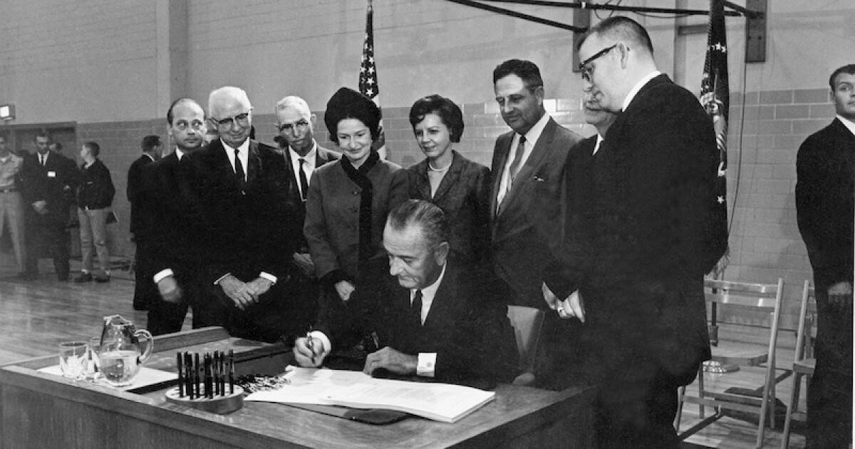 President Johnson signs the Higher Education Act on Texas State University campus in 1965.