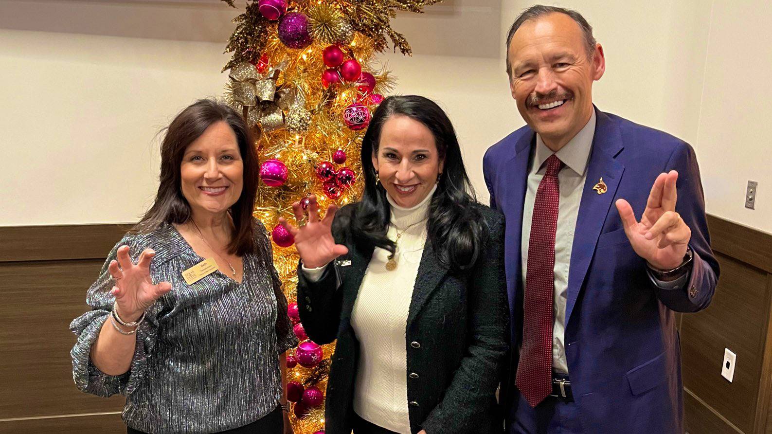 The President and First Lady Damphousse pose for a photo with an attendee at the TXST Holiday Open House.