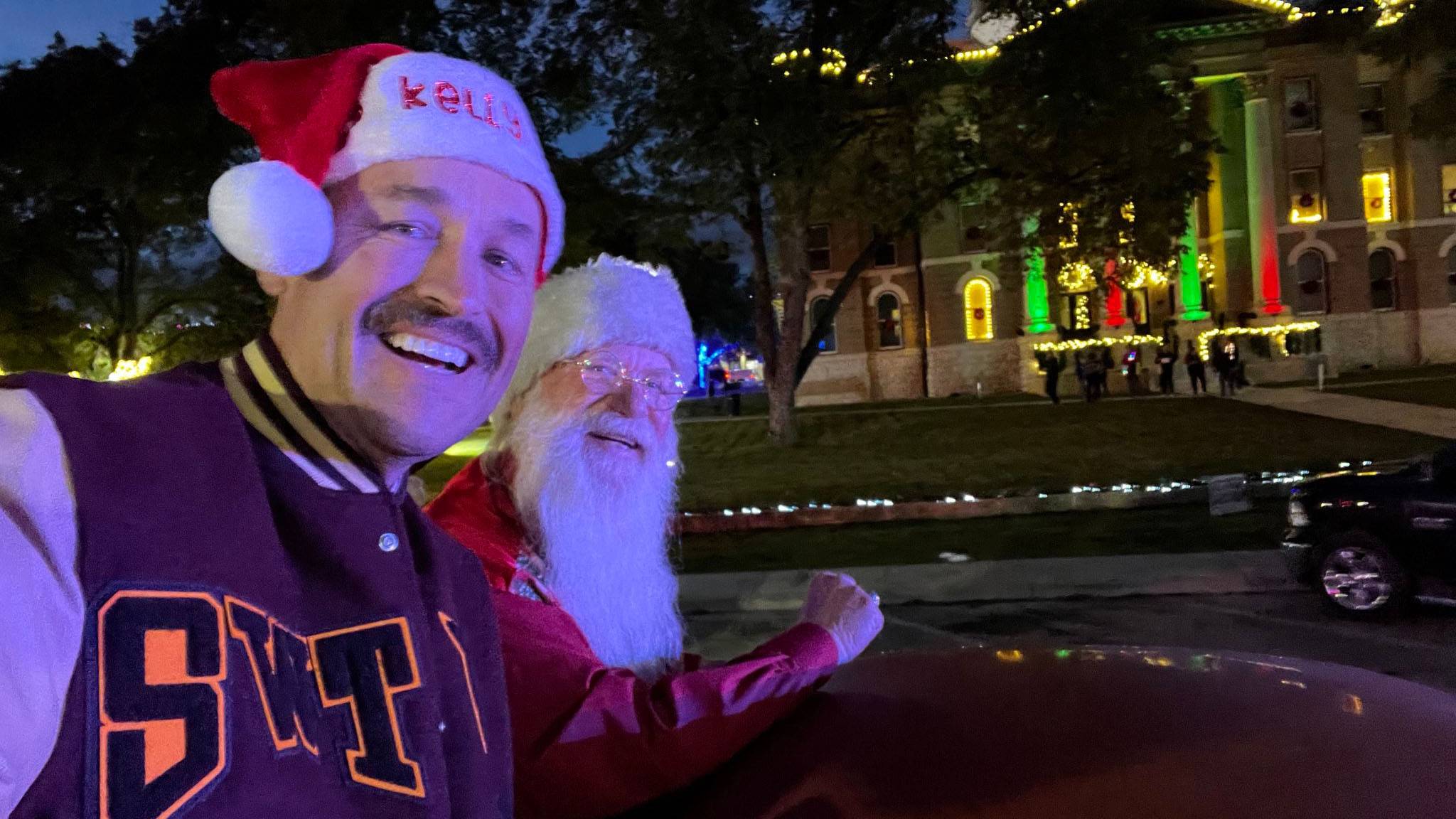 President Damphousse, left, poses for a photo with Santa on a car.