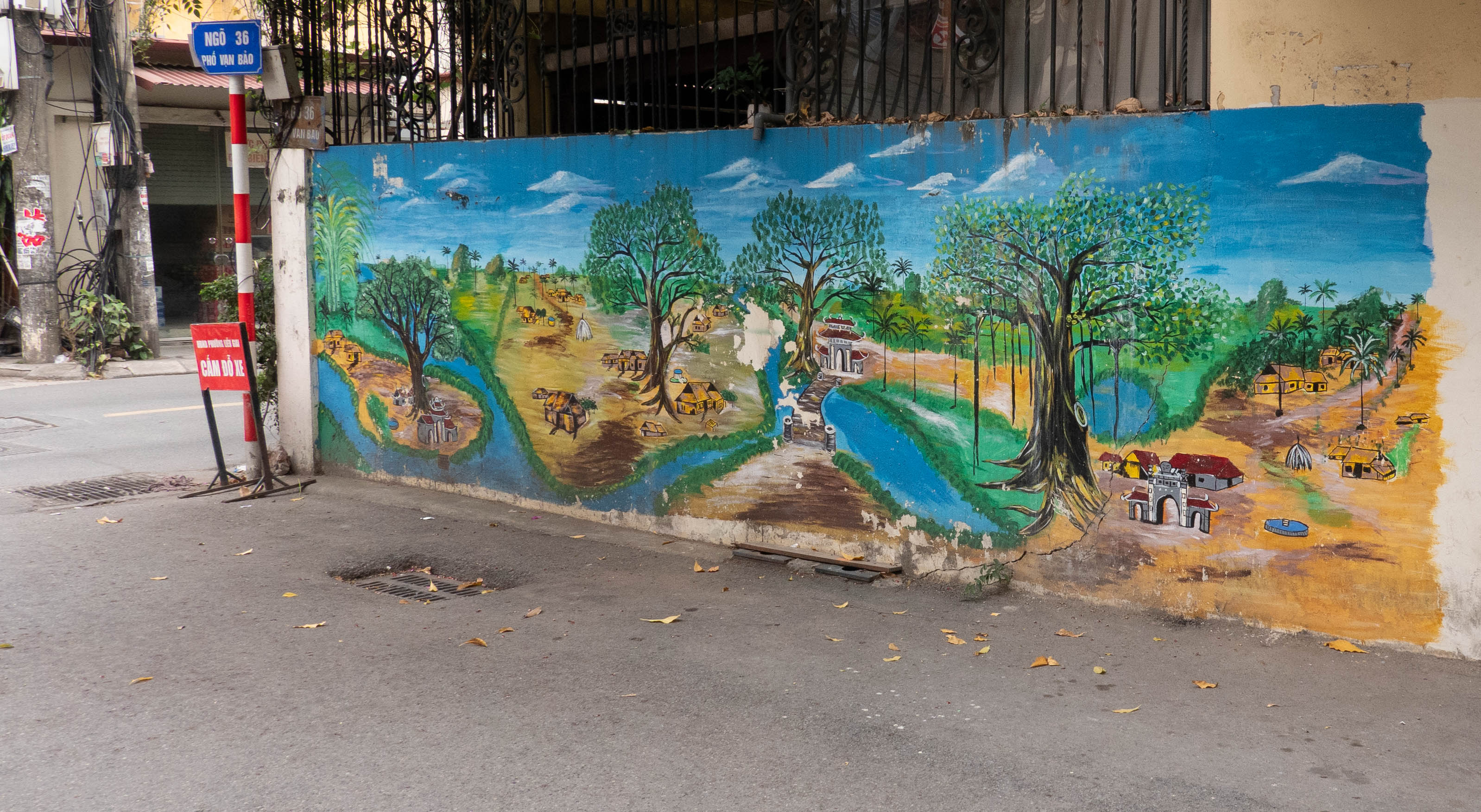 Mural of countryside on a wall in an alley off a street
