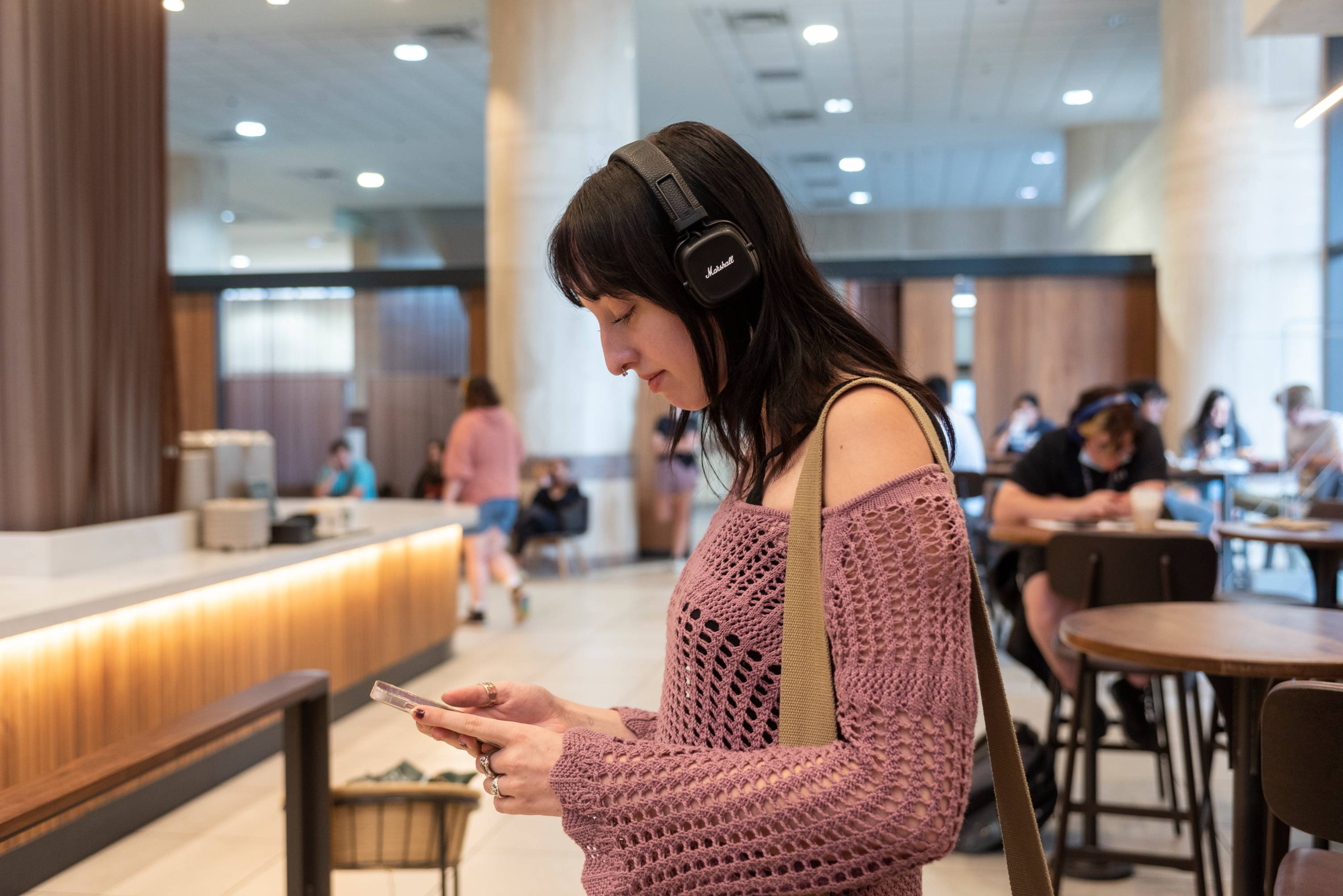 Student with headphones using phone