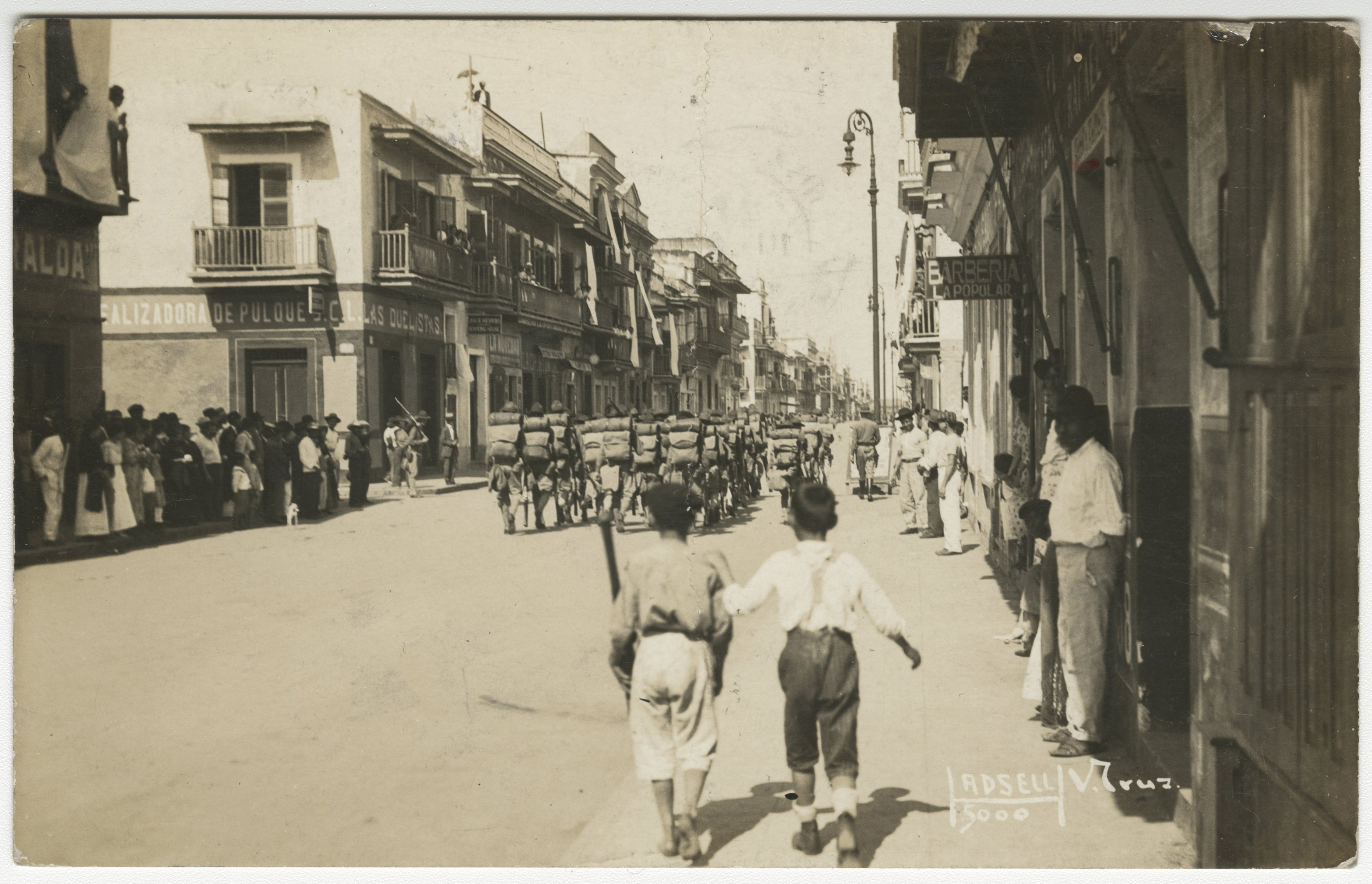 Photo of two boys on the street with soldiers