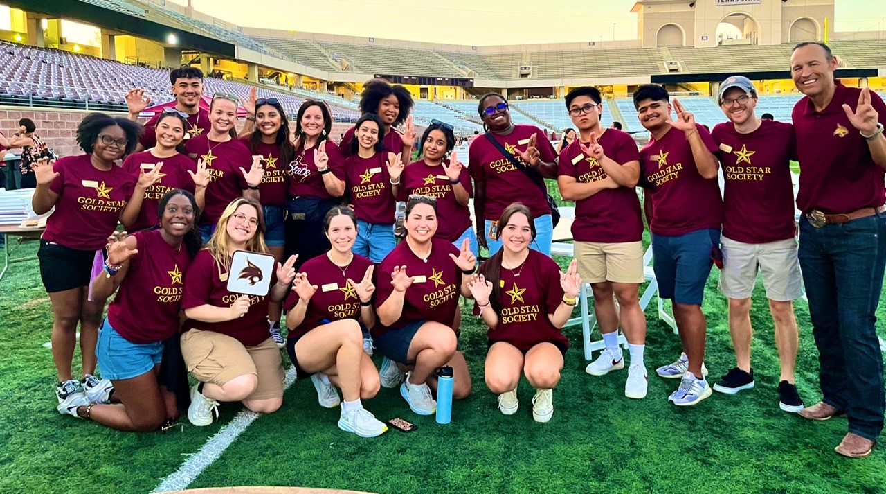 Gold Star Society members pose at Bobcat Stadium with President and Mrs. Damphouse