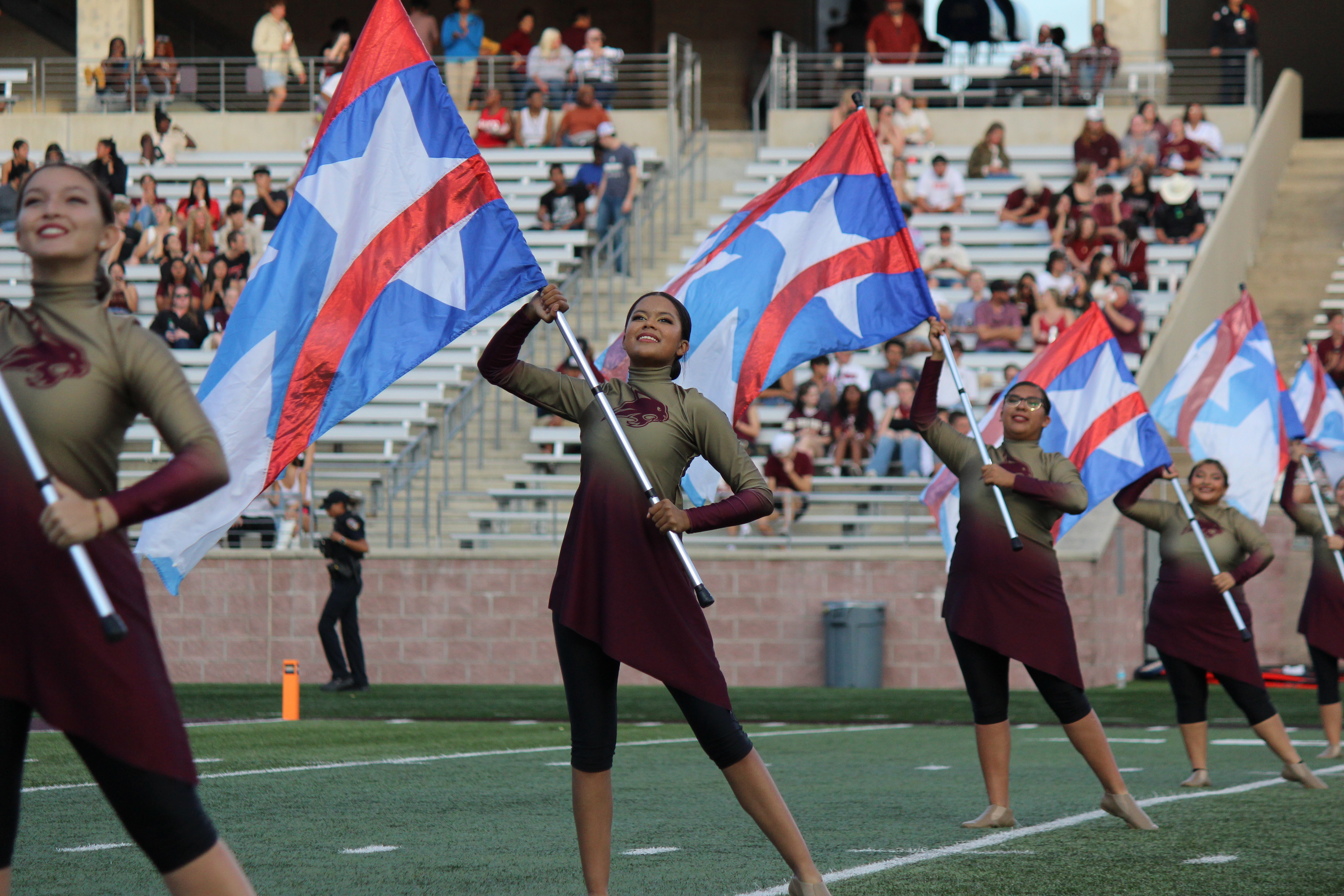 Color Guard members on field holding patriotic flags