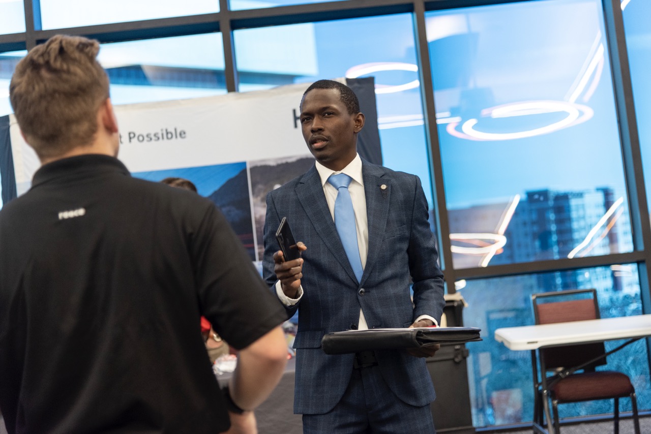 Man in suiting talking with student