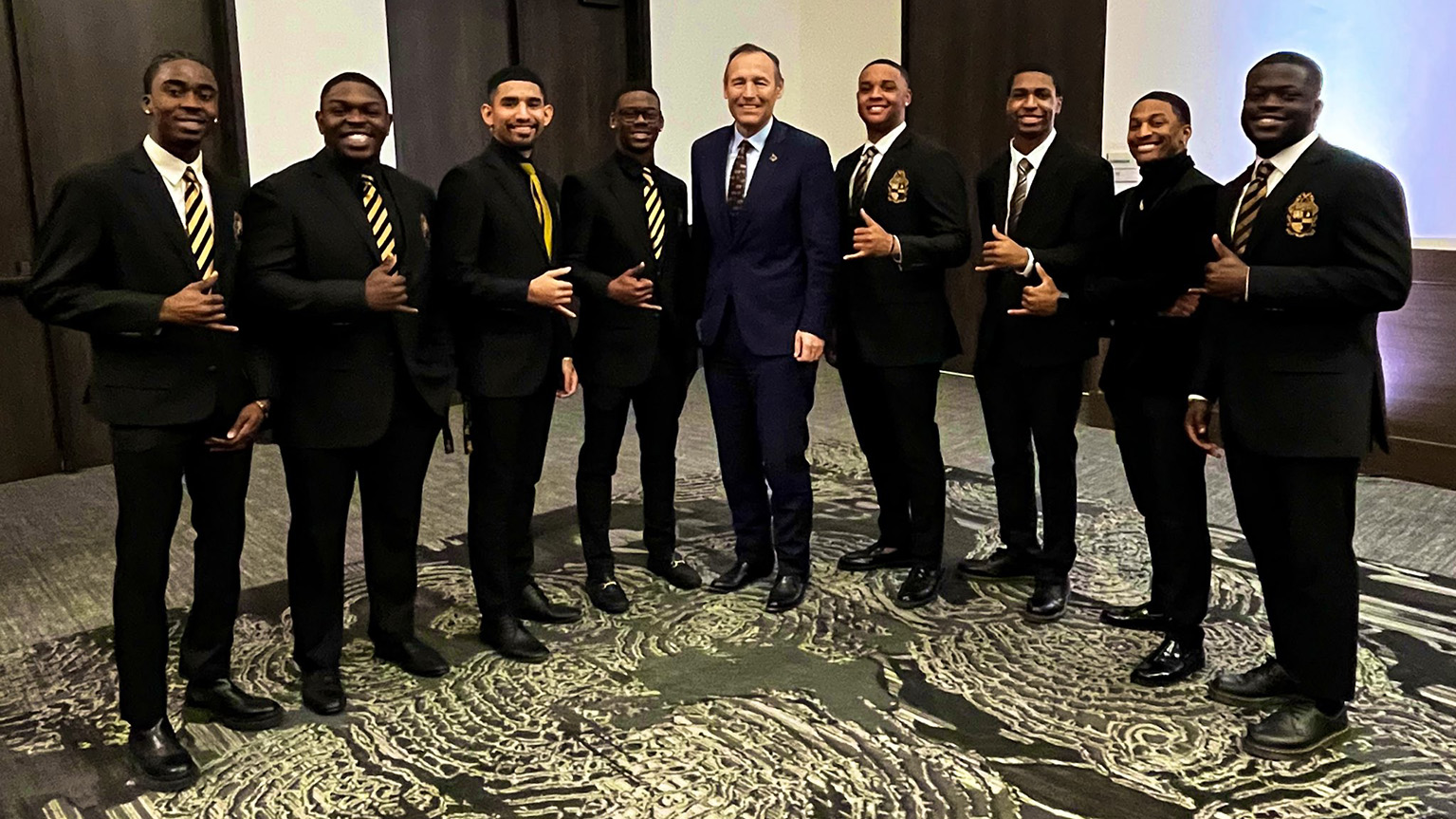 President Damphousse poses for a photo with performers from the MLK Celebration.