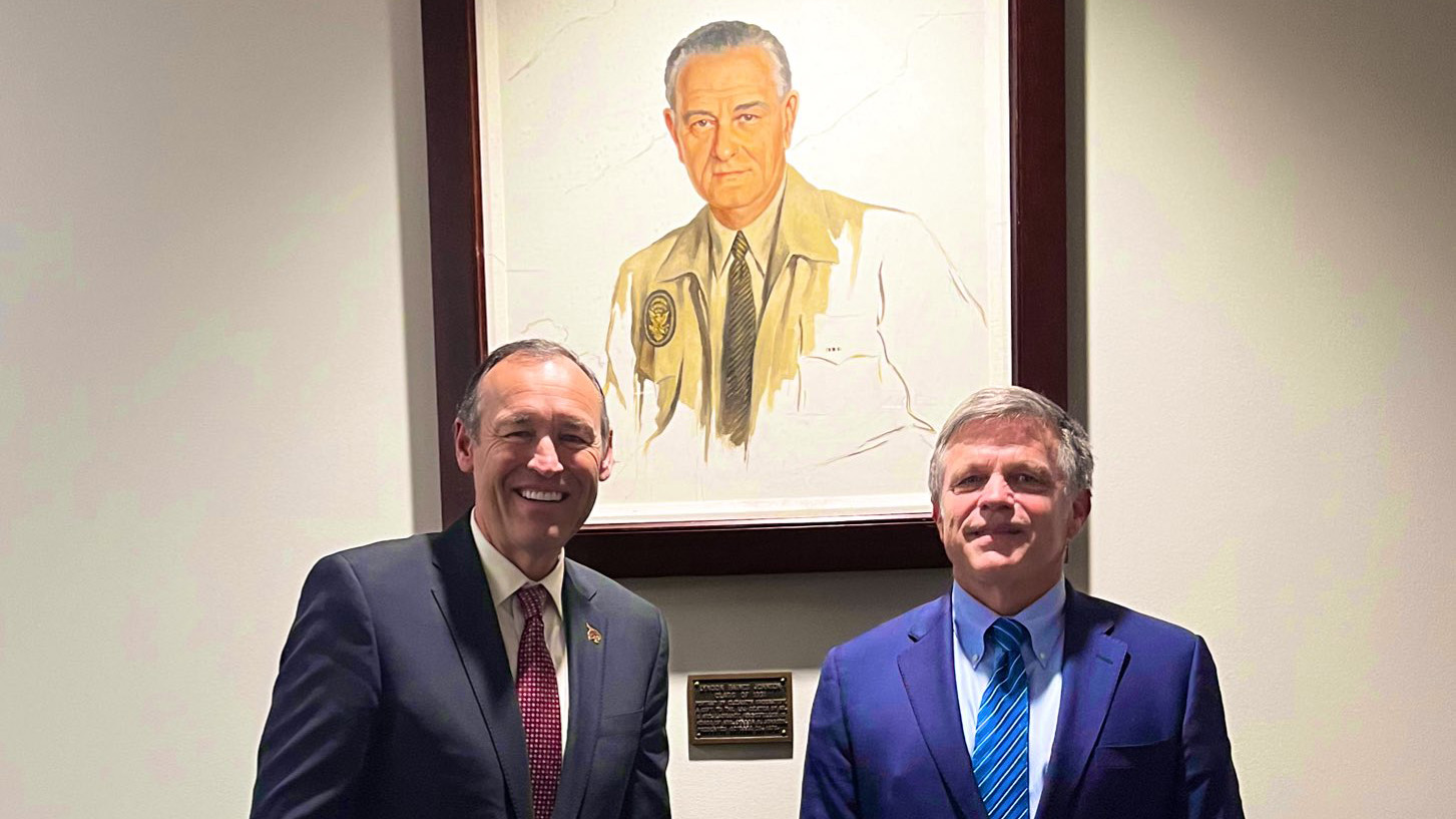 President Damphousse, left, poses for a photo with Professor Douglas Brinkley in front of a potrait of LBJ.