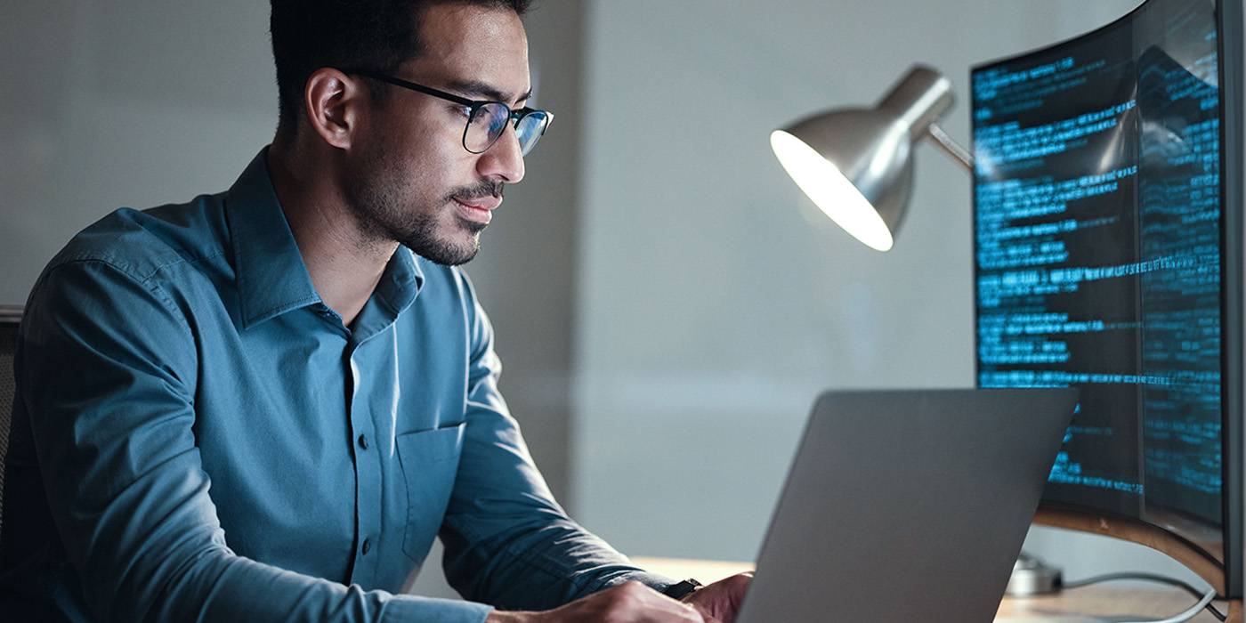 A man typing on a computer with a security lock icon on it. 