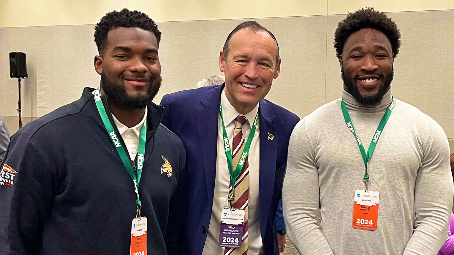 President Damphousse, middle, poses for a photo with two student athletes.