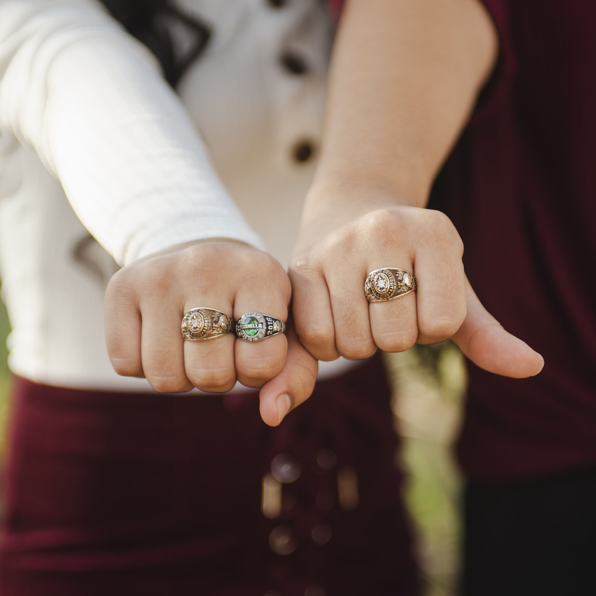 Two people's hands, showing their Texas State rings.