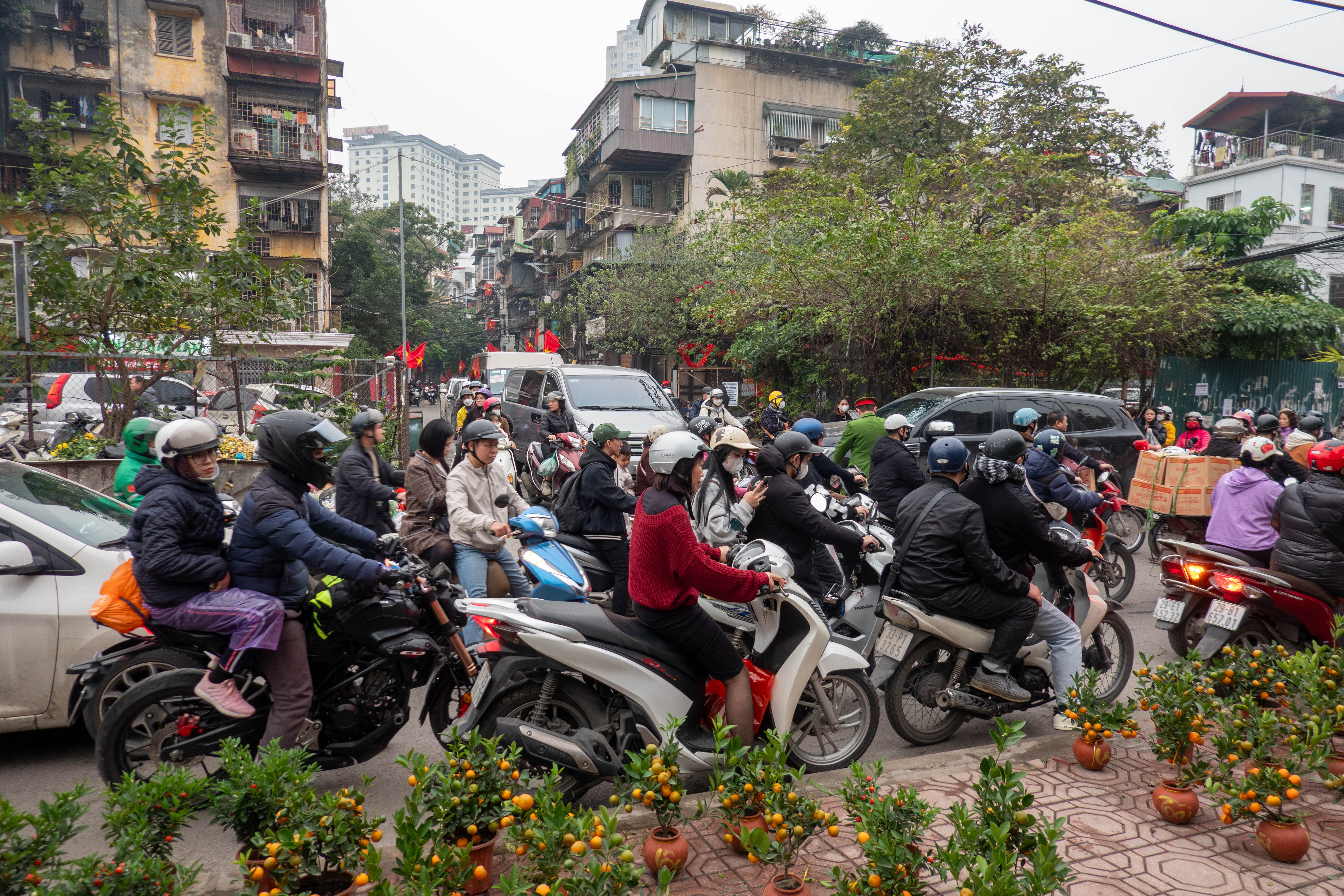 picture of congested traffic at an intersection of two roads. Motorcyles and cars fight for the same space.