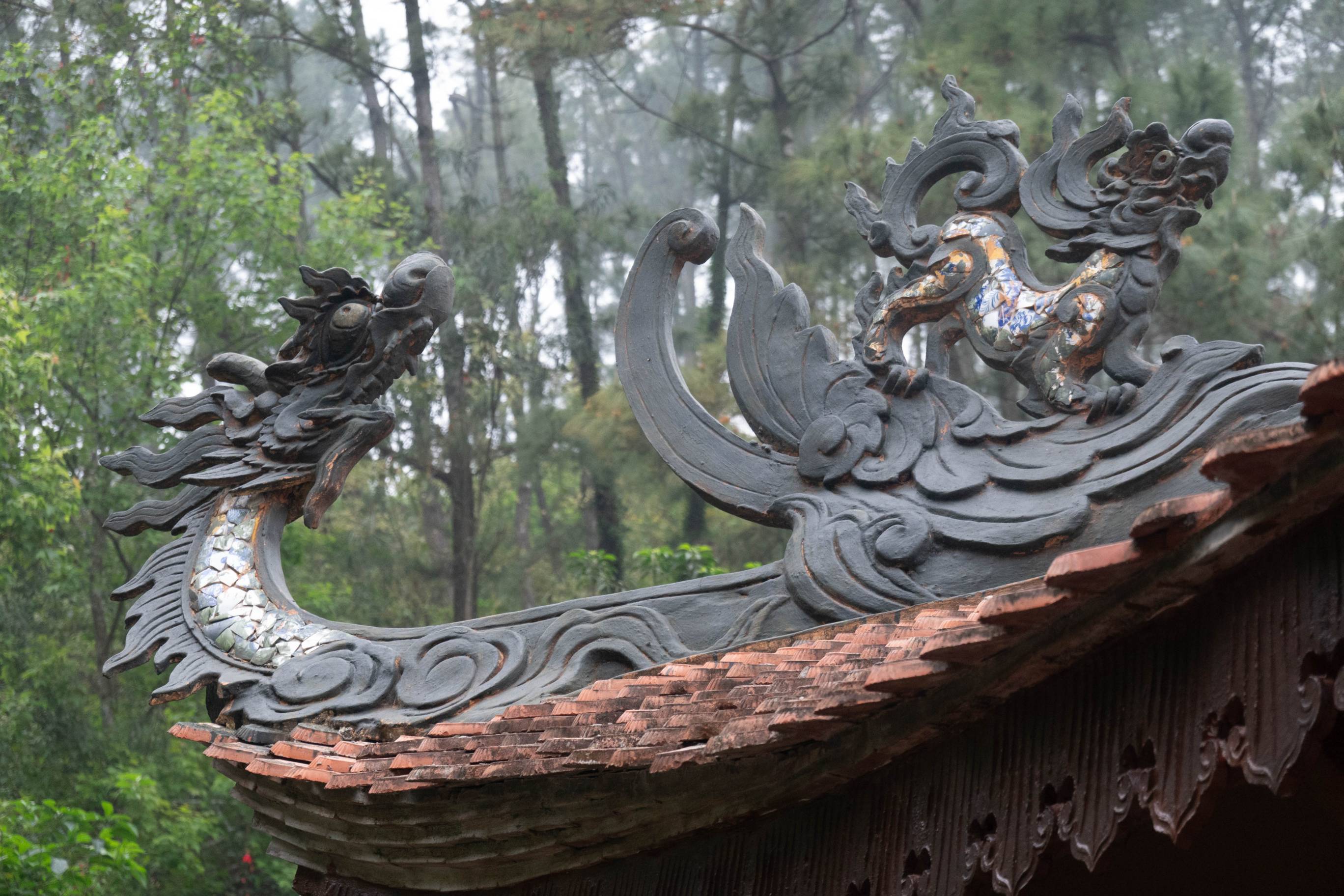 Picture showing a dragon and lion on a roof. The dragon is the figure on the left.
