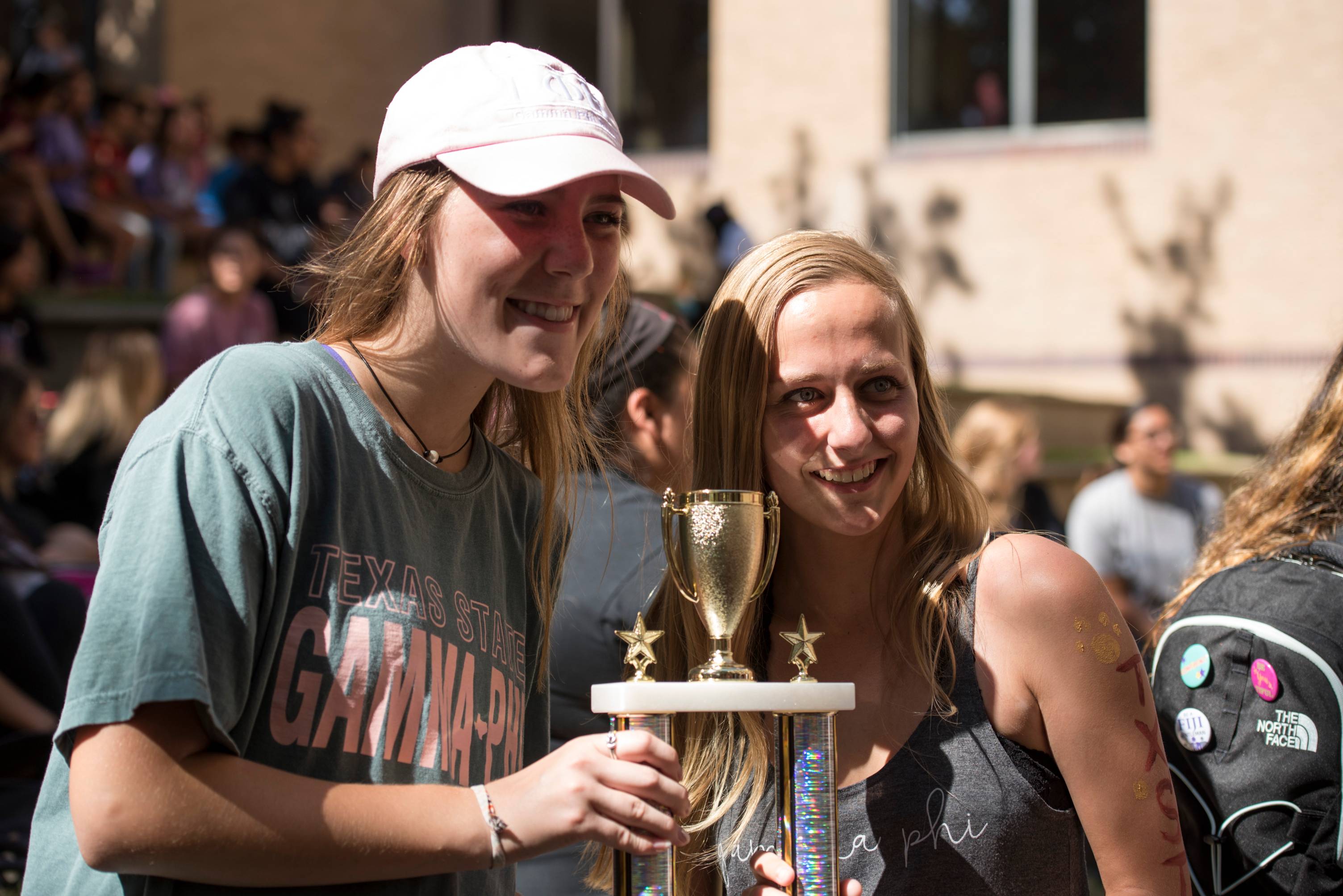 Image of two students holding a trophy 