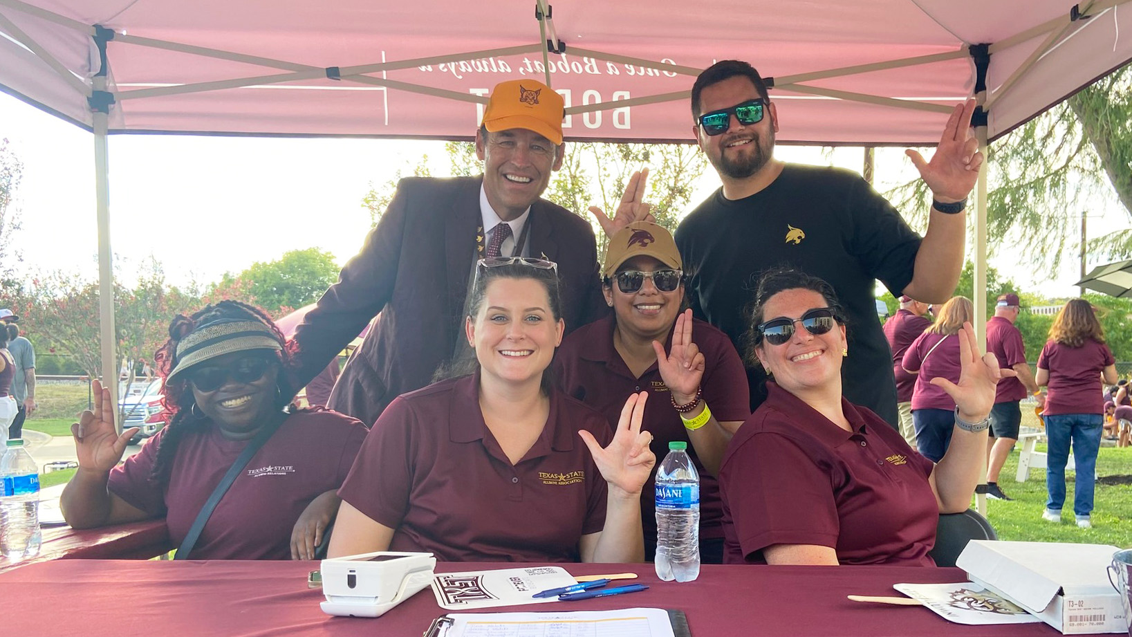 Group photo of TXST alumni staff working at Alumni tailgate booth