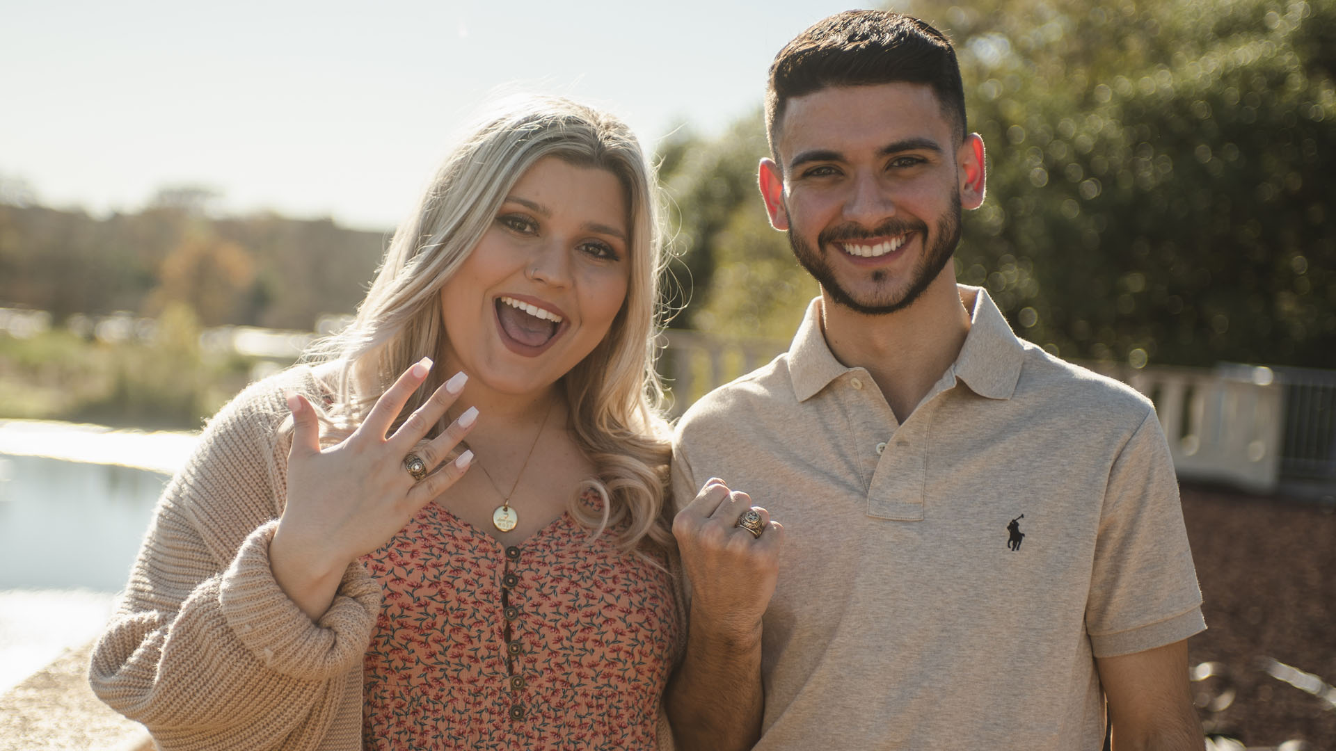 photo of two people smiling with rings on