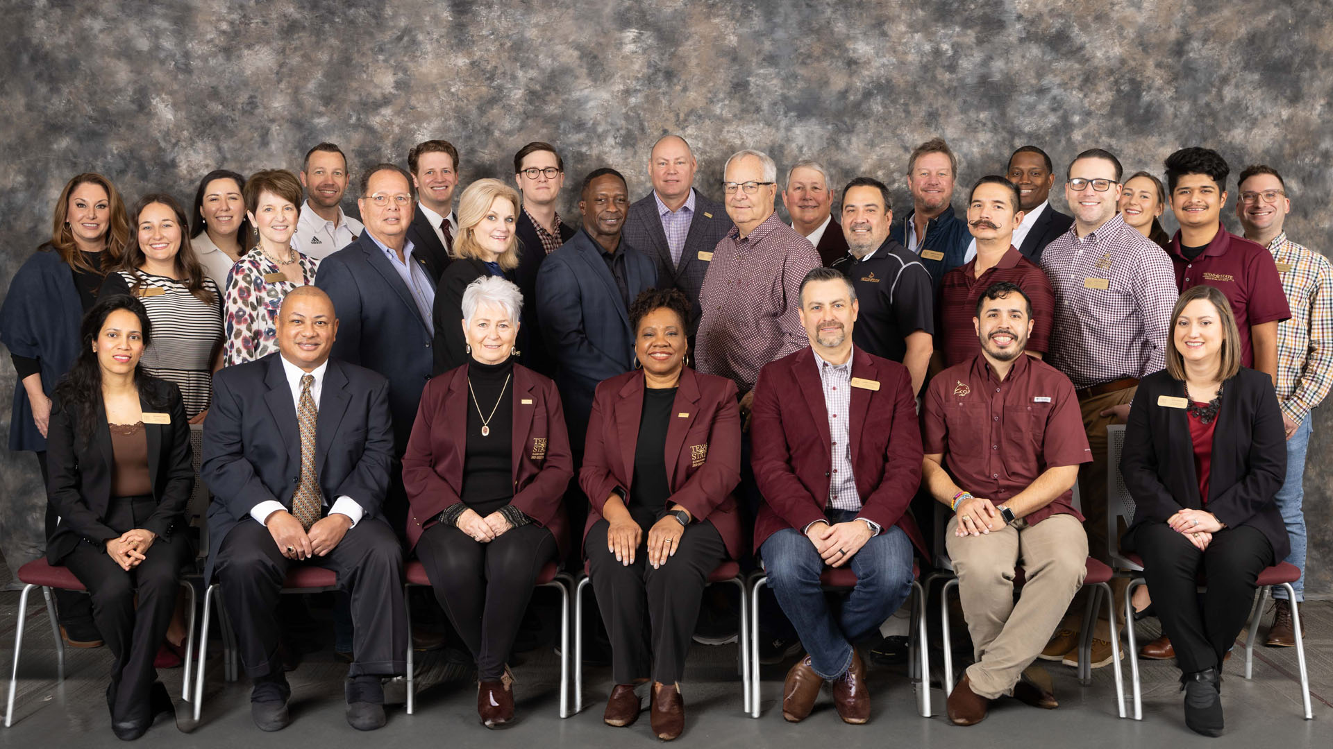 Group photo of board of directors against a grey background.