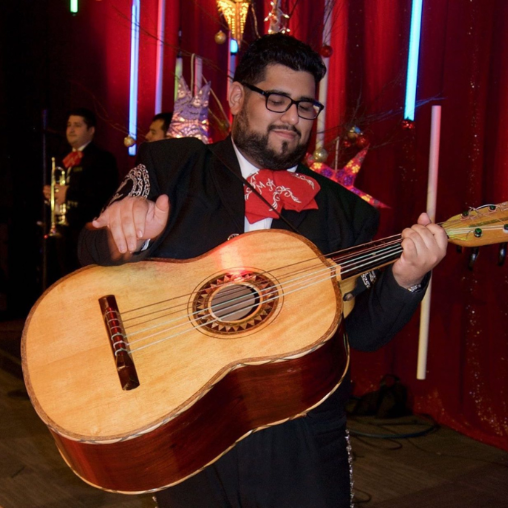 Miguel Cervantes playing the guitar dressed as a Mariachi
