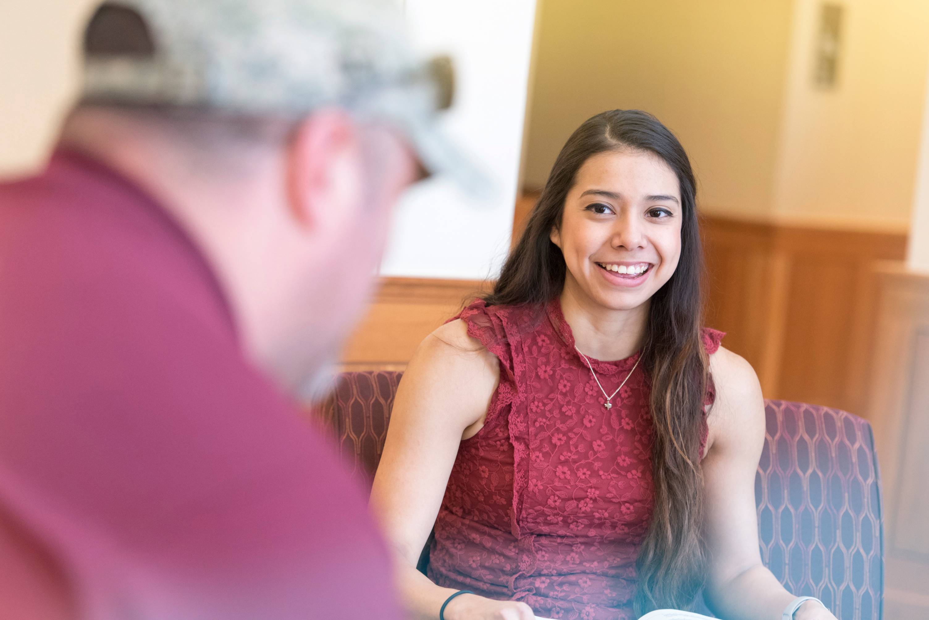 Student smiling while listening to another person