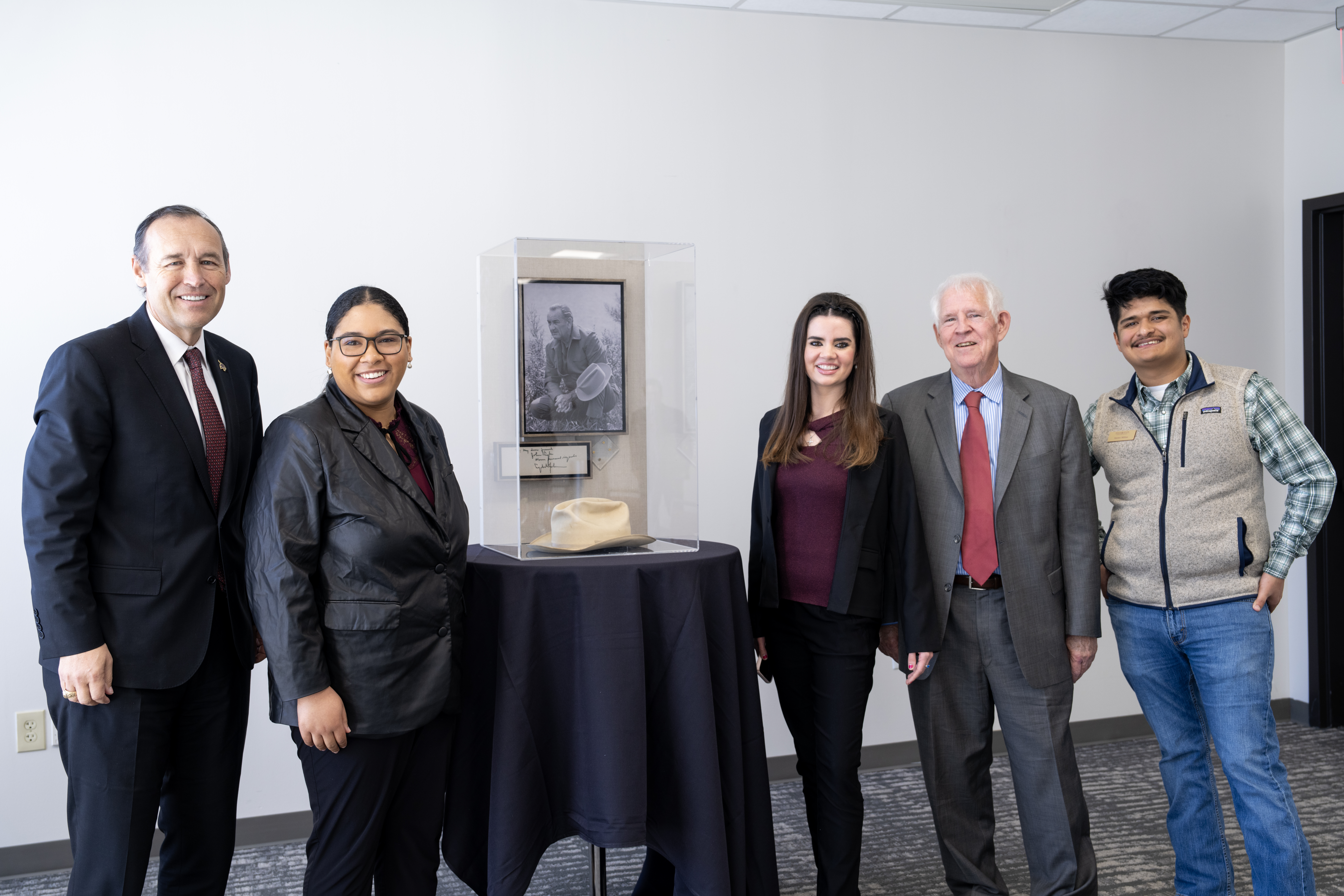 (Left to right) TXST President Kelly Damphousse, Lauren Green (Gold Star Society), Kiersten Florence (President of Student Government), Kevin Moomaw, Xavier Millan (Gold Star Society) pose next to LBJ's Stetson.