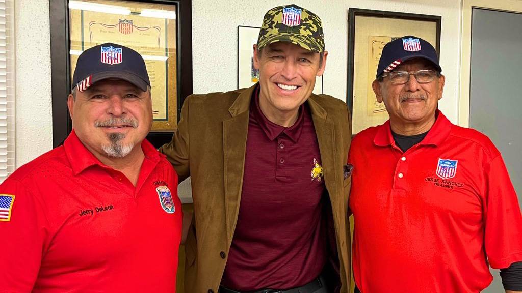 President Kelly Damphousse, middle, poses for a photo with two veterans on each side of him.