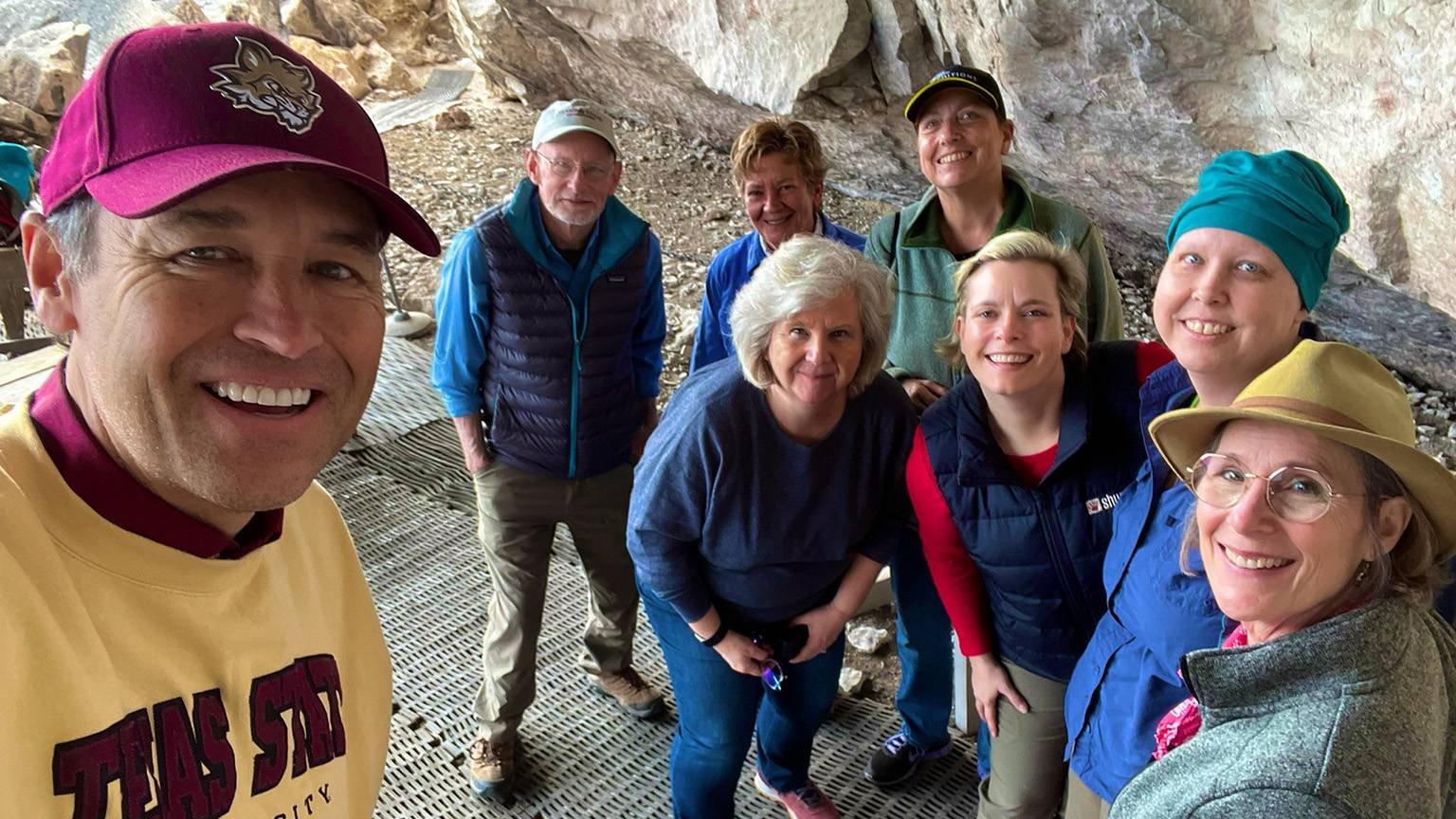 President Kelly Damphousse, left, poses for a photo with a group of staff and faculty during their hike to see rock art.